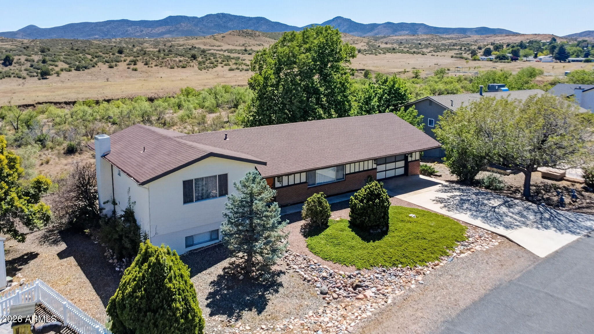 Tucked within Prescott Country Club, this exceptional home offers sweeping Bradshaw Mountain views and generous indoor-outdoor living spaces, all less than two hours from Phoenix. The modern kitchen flows seamlessly into a bright dining area that opens directly onto a massive 36' covered balcony with panoramic mountain views. The spacious, light-filled living room offers an inviting setting with plenty of room to relax and unwind. Two generous bedrooms share a full bath on the main level, while a convenient half bath is located just off the main living area . The versatile lower level is what truly sets this home apart. Accessible from both the main level and its own private exterior entrance, it features a living room with a fireplace, a full bedroom, a 3/4 bath, and a closet. Whether used as a guest suite, multigenerational living space, or a potential income-producing rental, the flexibility is unmatched. The fully fenced backyard is a private retreat featuring a hot tub, mature landscaping, and breathtaking Bradshaw Mountain views. Prescott Country Club offers residents access to a beautiful golf course, clubhouse, and resort-style amenities year-round. Whether you're looking for a full-time residence, a weekend escape, or a property with built-in income potential, this home delivers on every level.