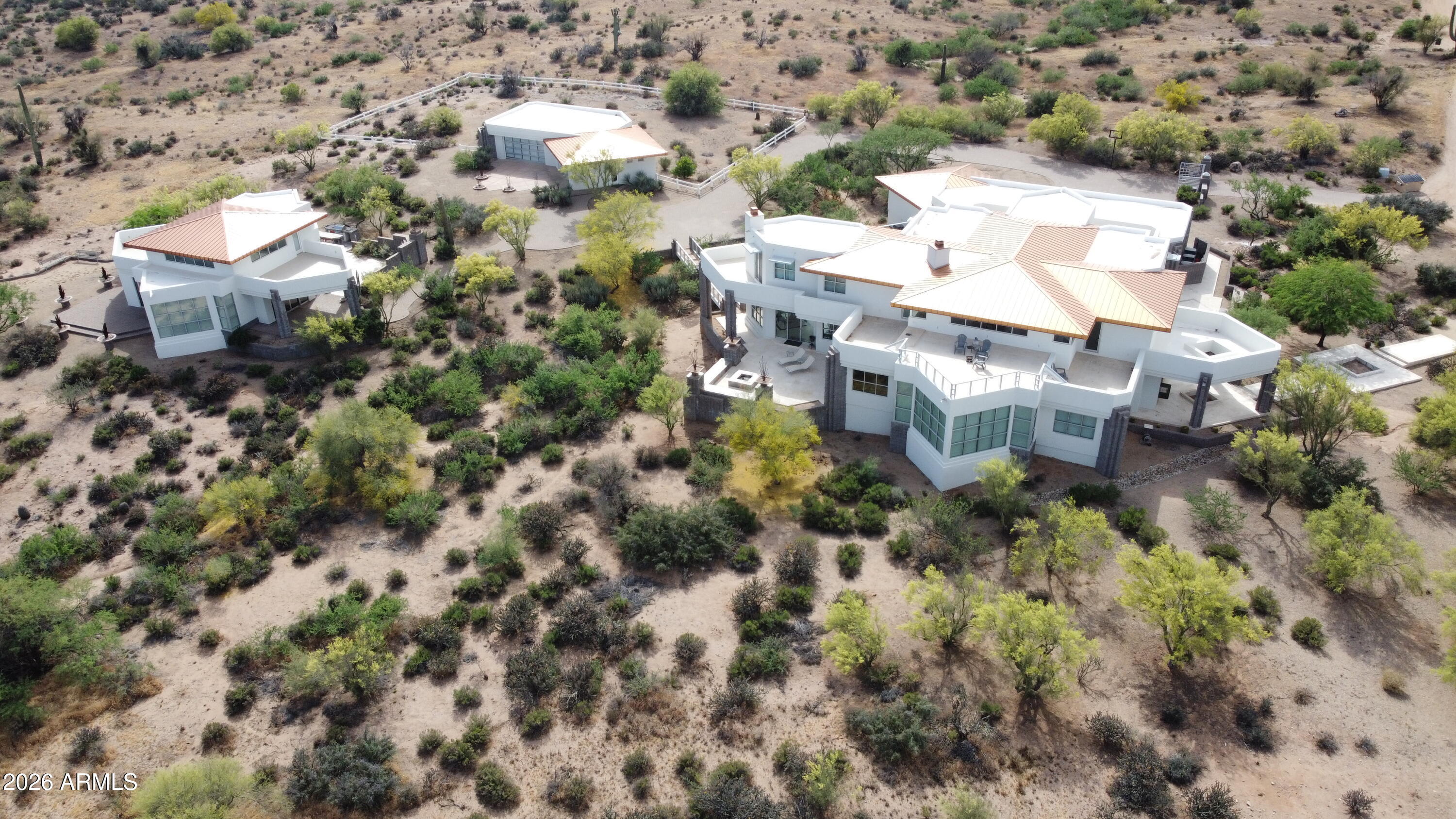 Welcome home to this breathtaking modern retreat, where every detail has been thoughtfully designed for the way you love to live. Nestled on 6 private acres with room for horses, the estate offers an extraordinary combination of space and lifestyle including a 1,652 sq ft detached guest home and an equally impressive 1,600 sq ft detached garage.
From the moment you step inside, soaring 20-foot ceilings draw your eye upward and set the tone for the grandeur that awaits. Entertain like never before with your very own indoor racquetball/sport court, stretching from the basement through the first level with glass on the upper level, perfect for friendly competition or cheering on the family.
Movie nights reach a whole new level in the basement, where a 135-inch projection screen and surround sound create an immersive theater experience without ever leaving home. The heart of the home is a spacious, chef-inspired kitchen featuring a double island with seating for eight, a butler's pantry/bar, and both casual and formal dining options -- ideal for everything from weeknight dinners to lavish gatherings.
Work, play, and unwind in spaces made just for you -- his and hers offices, a dedicated kids' playroom, and a charming library perched above the family room, perfect for quiet afternoons with a great book. As the day winds down, step out onto the upper-level wrap-around patios and let the open, starlit Arizona sky be your backdrop. Plenty of room for all your toys and workshop with the 6 car attached garage as well as a 4 car detached air conditioned garage with full bath. Main home is on just over 1.5 acres but listing is for sale of main home (5676 square feet), guest home(1652 square feet) on over 1 acre and additional 3 acres of vacant land for a total of 6 acres.
This isn't just a home -- it's a lifestyle waiting to be lived. Home is included in EPCOR water service.
Listing includes APN #'s 219-36-053L, 053K, 053C, 053F, 053G