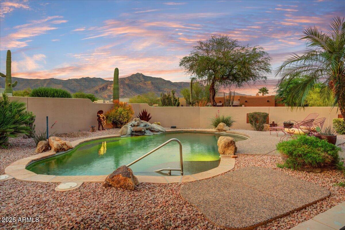 Stunning Superstition Mountain views & maximum curb appeal in Gold Canyon East! This 3 bedroom 2 bath home features a private outdoor retreat sporting a sparkling heated pool with breathtaking views, water feature, wrap around covered deck, professional landscaping and multiple dining/seating areas. 3 car garage and additional spacious storage room. 2026 complete roof re-coat, 2024 complete A/C replacement, 2022 pool vac & DE filter. HOA only $24/mo. Close to 5 Gold Canyon golf courses, restaurants, world class hiking in the Superstition Mountains & 35 min. to Phx Sky Harbor.