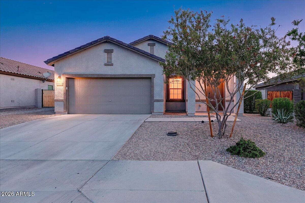 Beautiful single-story ranch-style home on an oversized 8,170-square-foot lot with stunning mountain views. Inside, enjoy 9-foot ceilings, 17-inch tile flooring, white shaker cabinets with stainless steel hardware, granite kitchen countertops, and Whirlpool stainless steel appliances, including a gas range. The spacious owner's suite features a generous walk-in closet. Added comforts include a whole-home water softener, reverse-osmosis drinking system, energy-efficient features, and a Wi-Fi programmable thermostat. The backyard backs to HOA-maintained green space and offers a covered patio, spacious yard, and convenient 8-foot double gate for added access and storage flexibility. Located minutes from Verrado, neighborhood parks, schools, shopping, dining, I-10, and Loop 303.