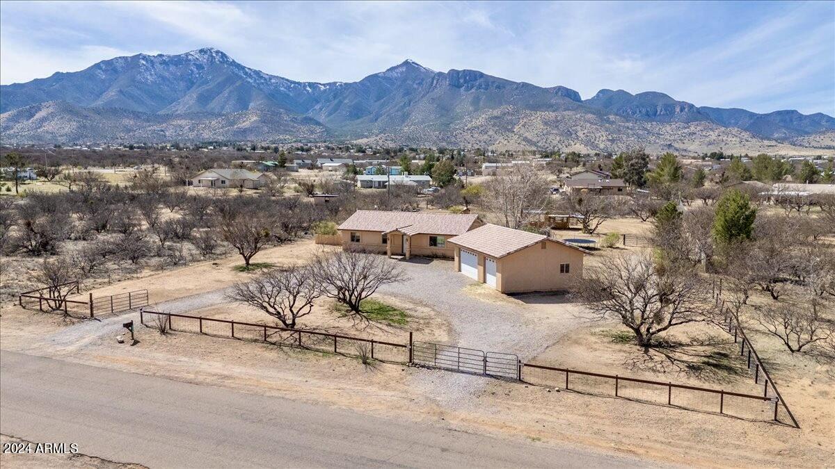 BACK ON THE MARKET AT NO FAULT OF SELLER OR HOME! Take in the mountain views from your custom site built home!  Open gorgeous views of the Huachuca Mountain range from your back covered porch.  This home features 3 bedrooms, 2 bathrooms, an oversized 3 car detached garage, plus a bonus room area.  Inside the home you will find granite countertops in the spacious kitchen, large bedrooms, vaulted ceilings, and a bonus, lockable room off of the primary bedroom.  The exterior offers a green grass backyard, fully fenced horse area, dog run, RV storage space, horseshoe drive and the huge garage!  All of this directly off a paved road, with no HOA, and a private well!!!  This one is ready to be yours!
