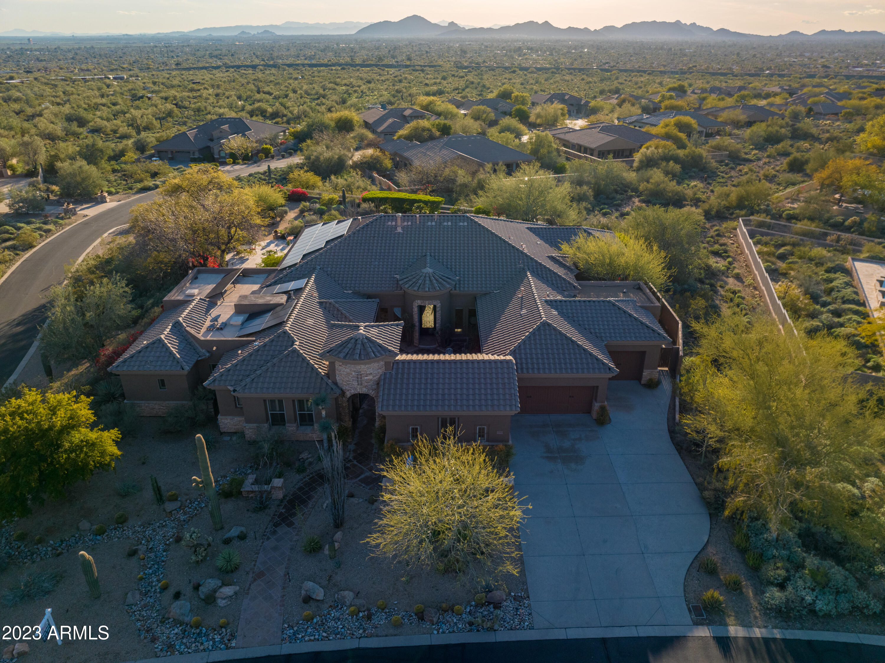 This beautiful McDowell Mountain Ranch view property is sure to impress. Mesmerizing panoramic city light & mountain vistas from this quiet, elevated foothills location are unparalleled. Sold fully furnished including owned solar with 5BR/5.5BA of luxurious single-level living. No interior steps. Expansive Cantera stone patio areas lead to multiple exterior sitting and dining areas, fireplaces, built-in grill, and a pebble tec pool - all immersed in a delightful desert specimen garden (featured in the Oct 2013 issue of Phoenix Home & Garden). Truly now a mature botanical oasis providing stunning sunsets, with a low maintenance and private outdoor living experience. An interior courtyard connects to a private entry casita, and the main house ensuite bedrooms additionally are split from the master bedroom and retreat. A bonus play/media room includes an additional garden exit, as do both the dining room and den. The chef's kitchen with stainless appliances, gas cooking, multiple ovens, island, and extensive granite counters. Custom upgrades throughout include a spa inspired primary bathroom with modern walk-in shower, soaking tub, and 2 oversized walk-in closets for the ultimate storage solution. Travertine flooring, 12' ceilings, dramatic stone entry and custom iron gates welcome you home. Sonoran Estates is gated and one of the lowest density communities in MMR, featuring large homesites & natural desert open areas between homes. It is near McDowell Mountain Golf Club, and abuts the protected land of the Frank Lloyd Wright Foundation and Taliesin West. Close to excellent schools and North Scottsdale activities with convenient proximity to reach Sky Harbor. A lovely desert home with upscale finishes and thoughtful, efficient improvements.
