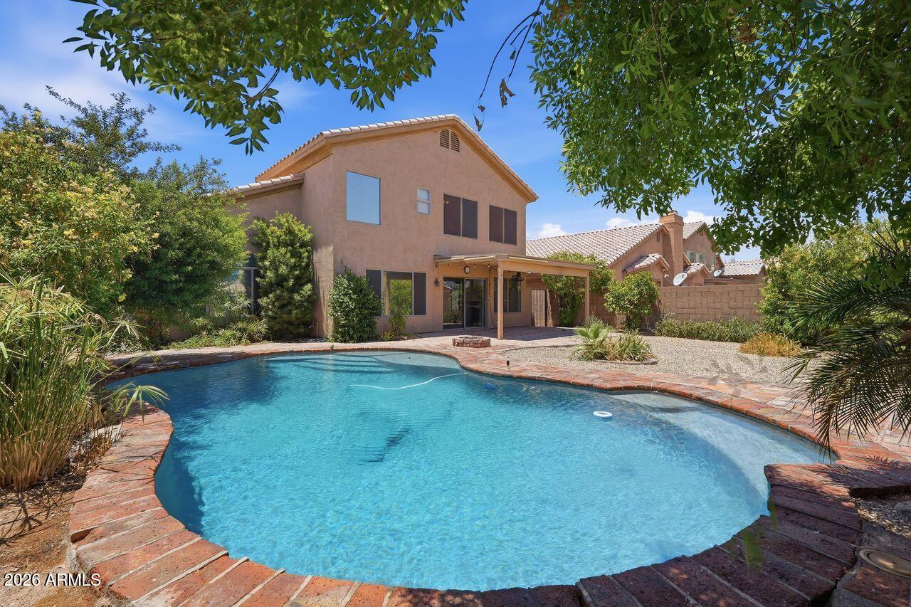 Located in the heart of Ahwatukee, this beautifully maintained 5-bedroom, 3-bath home offers 2,337 sq ft of living space with NO HOA! Escape the Summer heat with a backyard pool and covered patio. Freshly painted interior, elegant hardwood flooring, and a cozy gas fireplace create warm, inviting living areas. A downstairs bedroom and full bath are ideal for guests or multi-generational living. The kitchen shines with granite countertops, while sophisticated Pirouette blinds and plantation shutters add designer touches throughout. The primary suite impresses with vaulted ceilings. Enjoy one newer HVAC system and new air handler (2025) on the second system. Updated landscape system (2025).