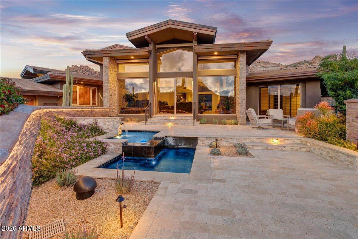 Stunning single-level residence in prestigious guard-gated Estancia, where refined luxury meets Arizona's dramatic skyline. The owners spared no expense upgrading this remarkable home. The desirable split floor plan captures breathtaking views of Pinnacle Peak, sparkling city lights, and vibrant Arizona sunsets.  The spacious great room features floor-to-ceiling glass and flows seamlessly into the formal dining area and gourmet kitchen complete with new top-of-the-line Wolf and Sub-Zero appliances, custom cabinetry, dual ovens, and wine room. The primary suite includes a generous walk-in closet, complemented by two en-suite guest bedrooms and a versatile den ideal for an office or media lounge. Outdoor living shines with a newly constructed pool and spa, outdoor kitchen, heated ramada, firepit, and lounge areas set against dramatic natural rock outcroppings, while the front patio offers a tranquil water feature and iconic Pinnacle Peak views.
A rare opportunity to own a private desert retreat defined by luxury, privacy, and unforgettable vistas