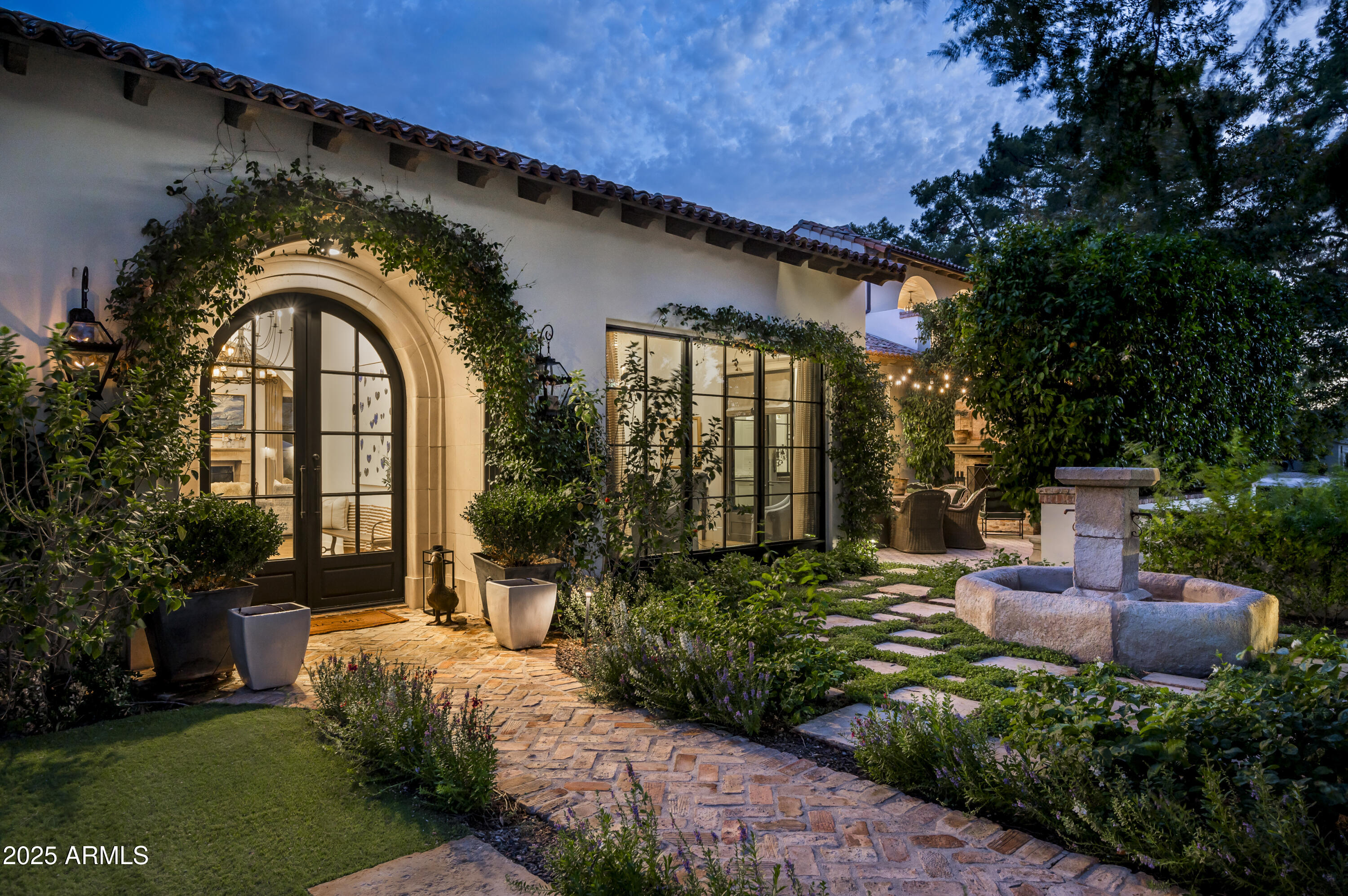 This exquisite Santa Barbara-style estate, nestled in the prestigious Paradise Valley Farms community of Scottsdale, redefines luxury living with its seamless blend of historic charm and modern amenities. Fully remodeled in 2017, the architectural design and enhancements were guided by Jeff Doubet, a renowned expert in authentic Santa Barbara-style architecture. The result is this 7,907 sq/ft masterpiece, set on an acre of land, embodying timeless elegance and meticulous craftsmanship. Boasting 5 bedrooms, 4 full bathrooms, 2 powder rooms, an office, and a game room, this home combines the allure of classic design, with the finest modern finishes and gives any family ultimate flexibility in how the home is utilized. Upon entering, you'll be greeted by a soaring foyer that leads to
an open-concept living space. With solid wood flooring crafted
from a historic Gin Mill dating back to the late 1800s. As you step
into the family room you will be greeted by reclaimed wood beams
from a barn in Quebec, Canada, along with an antique Limestone
Fireplace surround.

Culinary enthusiasts will adore the gourmet kitchen enriched with
custom Desert Cove Cabinetry and equipped with top-of-the-line
appliances including two Asko dishwashers, Scotsman nugget ice
maker, 60" Wolf gas range with double griddle and electric double
ovens, a Wolf steam oven, Wolf microwave, and a Miele built-in
coffee maker with its own water fill. The centerpiece is an
expansive marble island over 9 feet long, featuring maximum
storage capacity and custom pull-out shelving inside cabinets.
Additional features include built-in storage for baking
ingredients, two Subzero refrigerators, four Subzero freezer
drawers, and hand-forged hinges and pulls on the refrigerators to
create a vintage icebox design. The double farm sink looks out to
a quaint courtyard with a wood-burning fireplace and fountain that
are designed with antique limestone that was reclaimed from
France adding to the home's timeless appeal.

The main floor offers 4 bedrooms, 2 that are en-suite and 2 that
share a Jack and Jill bathroom, game room, formal dining room,
spacious family room area with a custom bar for entertaining, 2
powder baths, and a laundry room with 2 washers, 2 dryers, and
a dog washing station. Rounding out the exquisite main level is a
custom wine cellar that holds up to 650 bottles, adorned with
barrel ceilings and a custom iron door, and an expansive 4-car
garage with a commercial pressure washer and ample storage for
all your tools and toys.

As you make your way up the stairs, the entire second floor is
dedicated to the Primary Suite and his/her office. This private
sanctuary features a gas fireplace, a beamed ceiling, and a spa-like bathroom adorned in custom marble with a remote-controlled
jacuzzi clawfoot tub. Waterworks fixtures, dual shower heads, a marble bench in the shower, and a Mr. Steam steam shower are a few of the other appointments the bathroom offers. The oversized walk-in closet features custom built-in cabinetry, exquisite lighting, and a built-in washer and dryer for added convenience. The estate's outdoor features are equally impressive. The outdoor kitchen is a chef's delight, featuring a built-in Wolf BBQ, Wolf
fryer, Green Egg smoker, built-in pizza oven, and a TV for entertaining all your guests, along with a wood-burning fireplace made from the same reclaimed Chicago brick that adorns all the patio flooring. The outdoor space also includes a built-in bar and a secret garden dining terrace. The luxurious limestone pool deck and Jacuzzi are designed for ultimate relaxation. A tennis court with an adjustable half-court basketball hoop, complete with a ball return, offers recreational opportunities for all ages and enhances the estate's grounds, leaving even the most discerning buyer wanting nothing more.

This extraordinary estate is a masterful blend of historic charm
and modern amenities, designed for those who appreciate the
finer things in life. Whether entertaining guests or enjoying quiet
family moments.