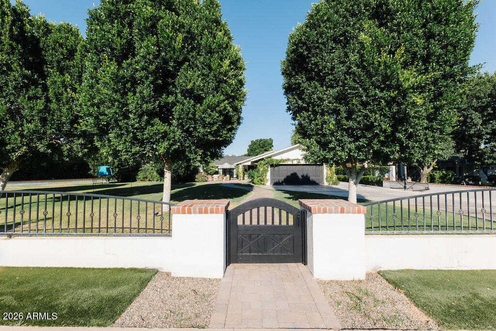 Magical Arcadia , gated with green grass ,mature landscape and a timeless ,remodeled ranch estate.  Sunlight flows thru the home, details unfold .  The kitchen with warmth and sophistication becomes the heart while opening up to a book lined family room. Four bedrooms with office/playroom on one side . The separate  master suite has a vaulted ceiling with views of the garden. Impressive laundry room , man cave with golf sim set up. Formal dining room and living room open to the front patio with fireplace. Happy Home filled with color and light .