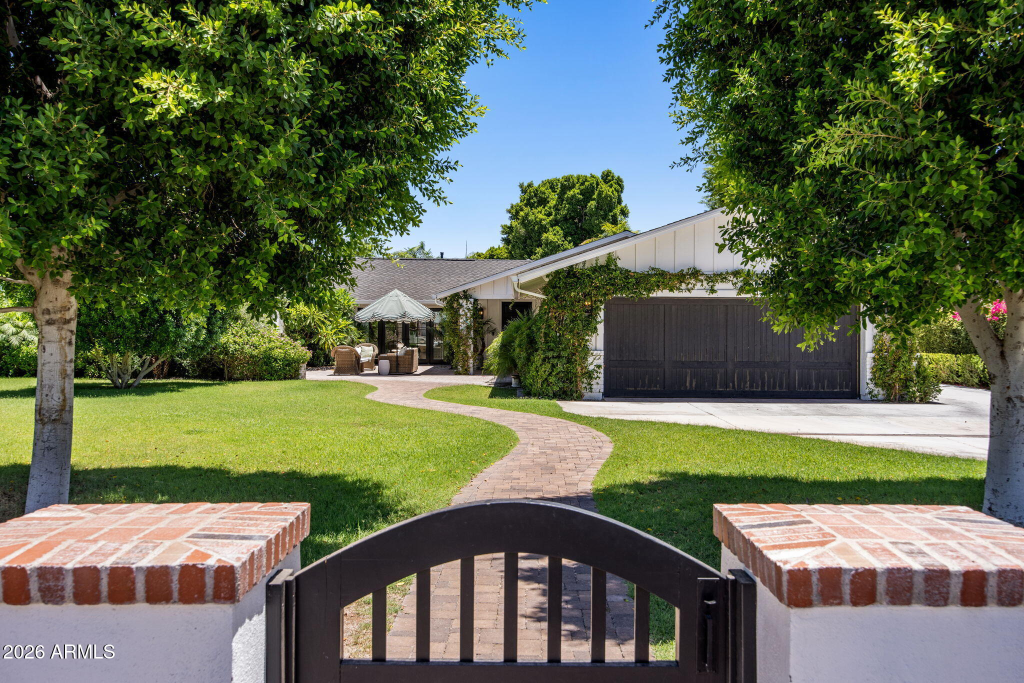Reimagined and repriced .  Magical Arcadia , privately gated.  Large green lawn and mature landscape with the perfect front gathering patio. French doors front and back add charm and natural light. The kitchen with warmth and sophistication becomes the heart of this home while opening up to a book lined family room. Featuring two ensuite bedrooms , two bedrooms with shared bathroom and an office/playroom on one side of the home , there are so many options .On the opposite side of the home, a separate primary suite has vaulted ceiling with views of the garden and private spa like bathroom. Plus a powder room , Impressive laundry room and man cave with golf simulator. Formal dining room and living room open to the front patio with fireplace. This is a Happy Home filled with color and light.