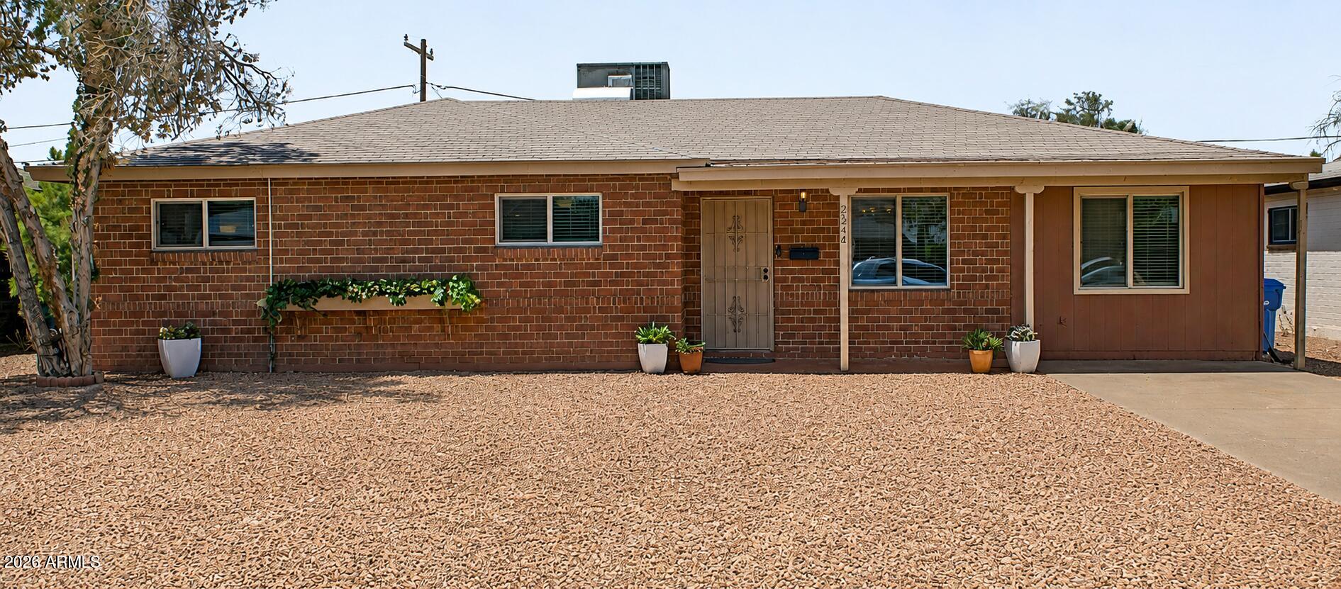 Timeless Bones, Modern Living. This Mid-Century Ranch sits in the heart of Central Phoenix -- minutes from Encanto Park, Phoenix College, the light rail, and quick freeway access to I-10 and I-17. The exterior brick delivers old-home character with a fully updated interior. Renovated kitchen with white shaker cabinets, stainless appliances, gas range, and granite counters. Dark wood-look flooring flows through main living areas. Two primary suites plus a den and living room make this a natural fit for multi-generational living or flexible work-from-home space. The bonus room has private exterior access and a dedicated mini-split. Backyard is a private retreat with brick walkway, circular grass feature, and mature landscaping. Refrigerator, washer, and dryer included.