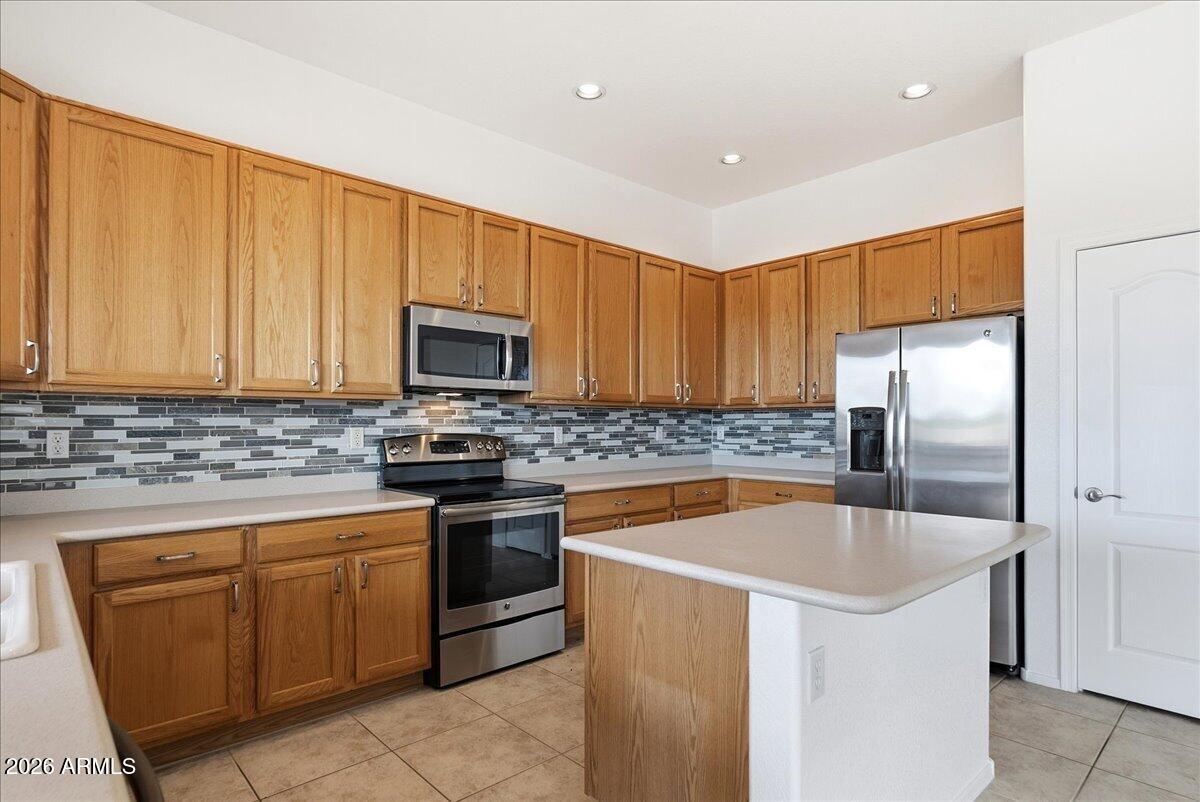 Spectacular home in the highly sought-after Peralta Trails community in Gold Canyon! This single-level home offers 3 bedrooms, 2 bathrooms, and 1,859 sq ft with a spacious and functional great room floor plan. Featuring 10-foot ceilings, abundant natural light, and an open layout, the living room and kitchen overlook the backyard, creating a seamless indoor-outdoor living experience. The kitchen includes solid surface countertops, tile backsplash, and stainless steel appliances.The home also offers a versatile den/flex space, generously sized bedrooms, and ample storage throughout. Additional highlights include a 3-car garage, large laundry room, and ceiling fans in every room.Step outside to enjoy a covered patio, private backyard, and beautifully updated desert landscape.
