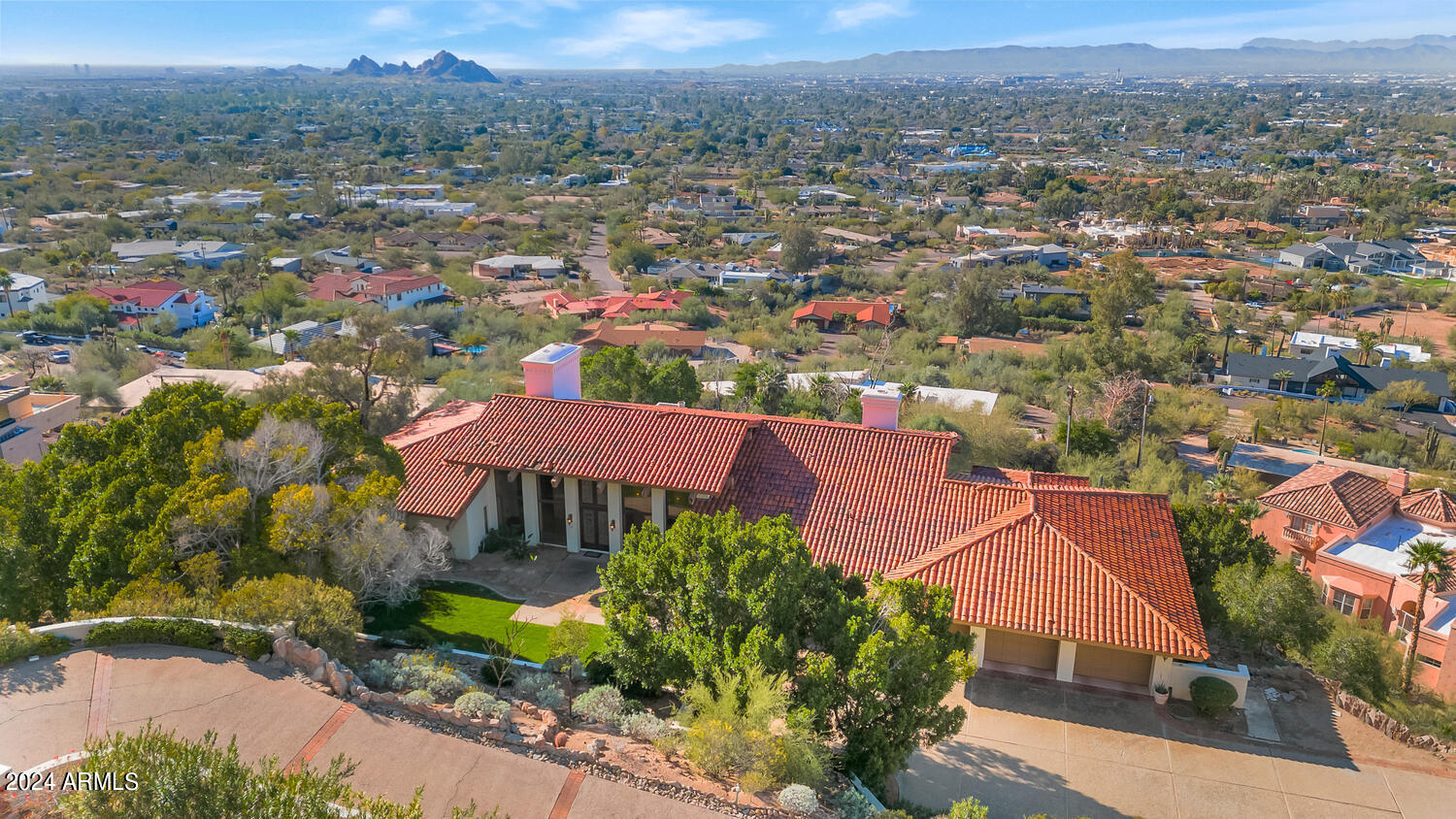 If you've dreamt of living high atop the city nestled into Camelback Mountain in a setting so breathtaking it's unimaginable, your search may have just ended. This special home is filled with natural sunlight and beautiful living spaces. Each room has its own unique design traits that take full advantage of the spectacular views. The kitchen is lovely, the great room has a grand fireplace as its focal point, the formal dining room has its own fireplace that creates exceptional ambience, the office is spacious and private, and the primary suite is a dream worthy place to begin and end each day. The special design features tongue and groove ceilings, exposed wood beams, intricate millwork, a restaurant style walk-up wet bar, and floor to ceiling picture windows.  The magnificent lot is over an acre and has a full guest house, putting green and exquisite negative edge pool overlooking the entire city with pristine unobstructed views as far as the eyes can see. This impeccable residence offers a setting so exquisite, so unique and so rare in one of the most desired areas in all of Phoenix. City lights, mountain views, hiking out the front door in a world class neighborhood, what more can you ask for?