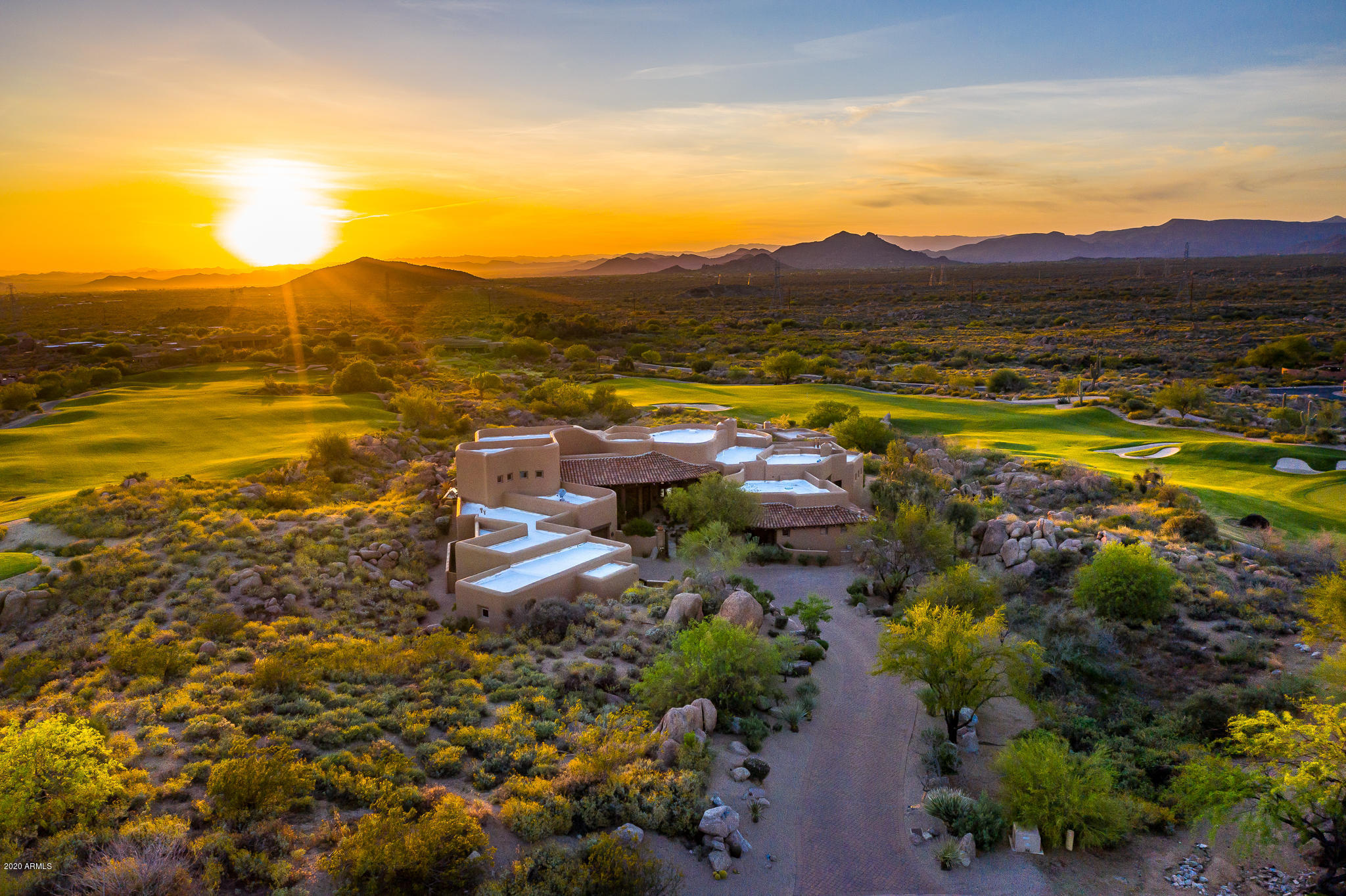 Perched high above the 3rd & 4th fairways of the Troon North Golf Course located within the gates of Talus at Troon North is framed this stunning home which offers golf course, mtn, city lights & the best sunsets Az has to offer. The outdoor living spaces feature tranquil privacy, large covered patios, 2 fire pits, negative edge pool/spa and a cascading 30ft stream. Designed by Lee Hutchinson & built by RS Homes this home was voted the BEST CUSTOM HOME OF THE YEAR by the Home Builders Association of Central Az. The main home is 6688 sf. The quality of the 3 br, library with built in bookshelf, office, game room and media room are second to none. You will enjoy the majestic views from many of the rooms in the home including the master br, great room, living room, kitchen, office and game room. Need a 748 sf detached casita? Look no further as this 1 br with separate living room is the perfect location for family and friends inc. a patio to enjoy the fabulous views. In addition the extra length, large 4 car garage affords ample space for the car/toy enthusiast.