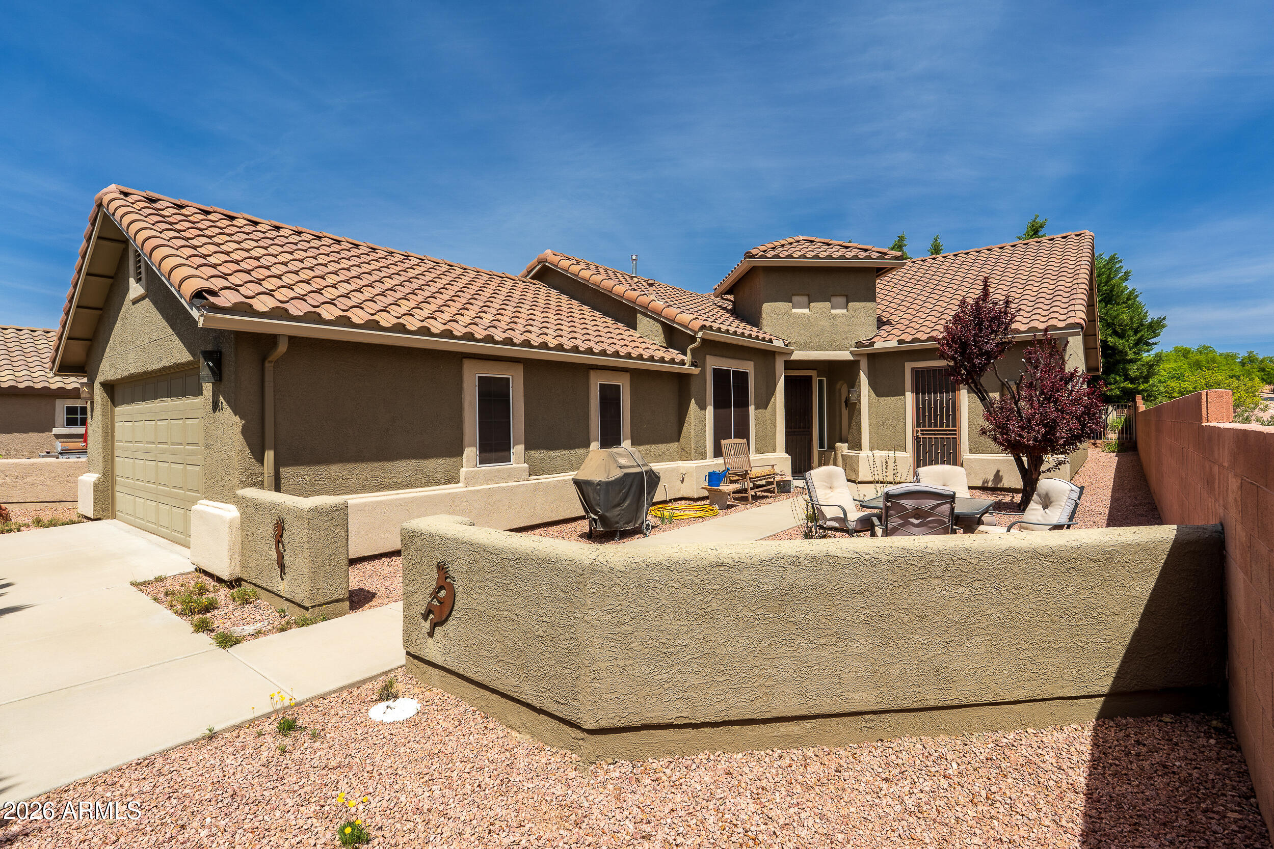Welcome to easy, low-maintenance living in the desirable Dorado subdivision of Verde Santa Fe, a sought-after 55+ community. Tucked away at the end of a quiet cul-de-sac on a private flag lot, this well-maintained 2-bedroom, 2-bath home with a dedicated den/office offers approximately 1,700 square feet of comfortable and functional living space.

Built in 2005 and recently refreshed with exterior paint, this charming stucco home features a tile roof, inviting front courtyard with flagstone seating, and added security screens for peace of mind. The versatile den includes its own door to the courtyard--perfect for a home office, hobby room, or guest overflow. Inside, the thoughtfully designed split floor plan includes a spacious primary suite with elegant French doors, a walk-in closet, and a relaxing bath complete with garden tub, separate shower, and frosted glass window for natural light and privacy. The living room is warm and welcoming with a gas fireplace, built-in entertainment center, and art niches, while remote-controlled "Top Down, Bottom Up" pleated shades add both convenience and style.

The kitchen is ideal for everyday living and entertaining, featuring granite countertops, center island, buffet area, wall oven, built-in microwave, electric cooktop, and a reach-in pantry. A slider opens to the covered rear patio with a flagstone extension--perfect for enjoying Arizona's outdoor lifestyle in a shady, serene setting.

Additional highlights include an interior laundry room with cabinetry, washer and dryer included, ample storage with hall and coat closets, and a 2-car garage with windows, shades, and a side yard access door.

Recent updates provide added value and peace of mind, including a newer A/C system, hot water heater, recirculating pump (all approximately 2-3 years old), and a new dishwasher.

This home offers privacy, comfort, and thoughtful upgrades in a welcoming community--ideal for full-time living or a seasonal retreat.