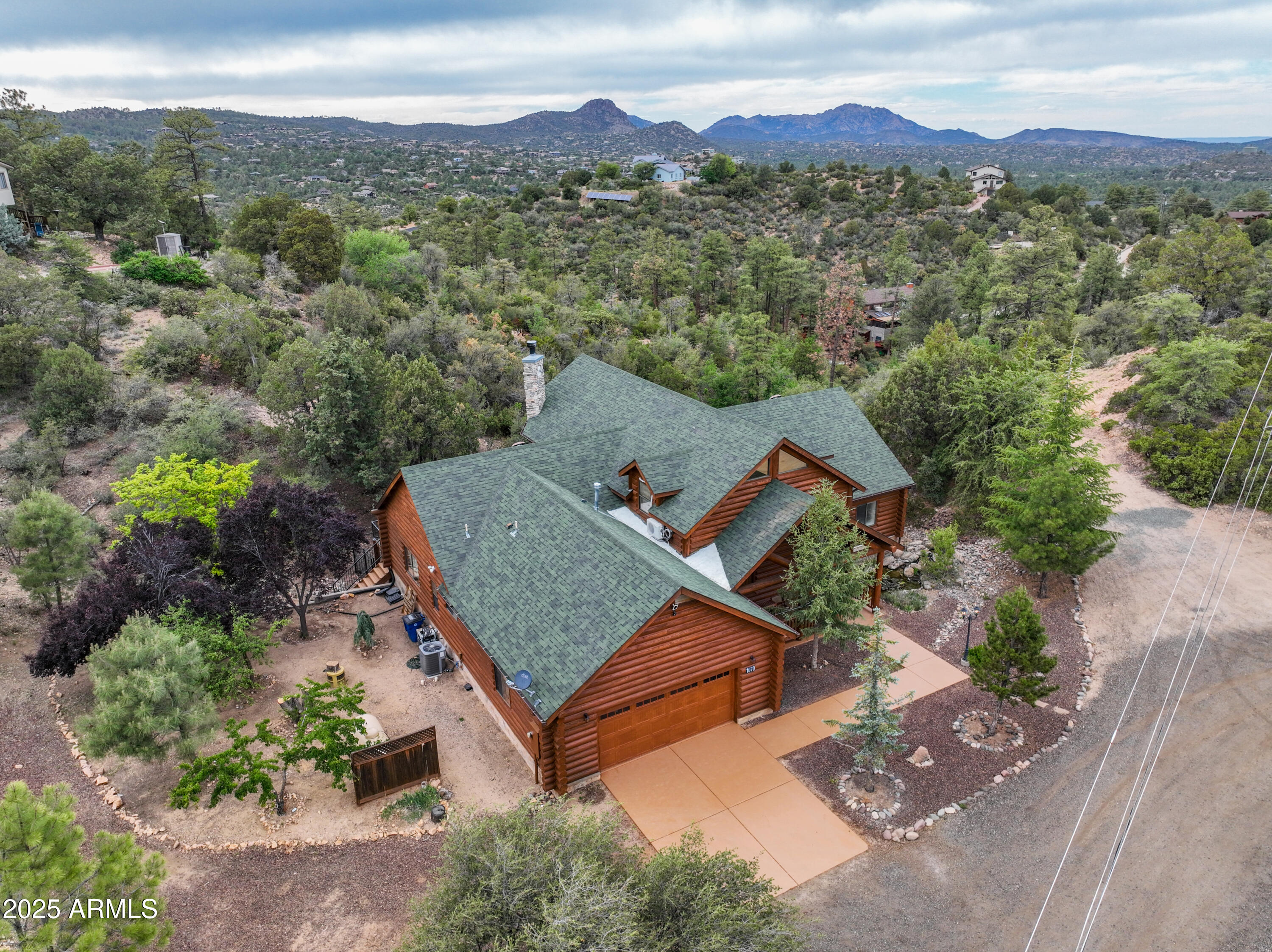 Quiet Pines is a 5,500 sq ft log cabin nestled in the Prescott mountains just 2 miles from downtown. Sitting on 1.8 acres with its own private well, this home offers five bedrooms, 3.5 baths, and an open living area featuring cathedral ceilings, a stone fireplace, and wall-to-ceiling windows. The kitchen showcases stainless steel appliances, a large island, and ample dining space. Inside, discover a wine cellar, movie theater, sauna, and karaoke bar. The spacious deck has a hot tub overlooking forested views, and enjoy evenings by the fenced backyard's fire pit. The parcel allows for a guest house or lot split to build another home. Quiet Pines blends rustic charm with modern amenities—ideal as a primary residence, vacation retreat, or investment.
