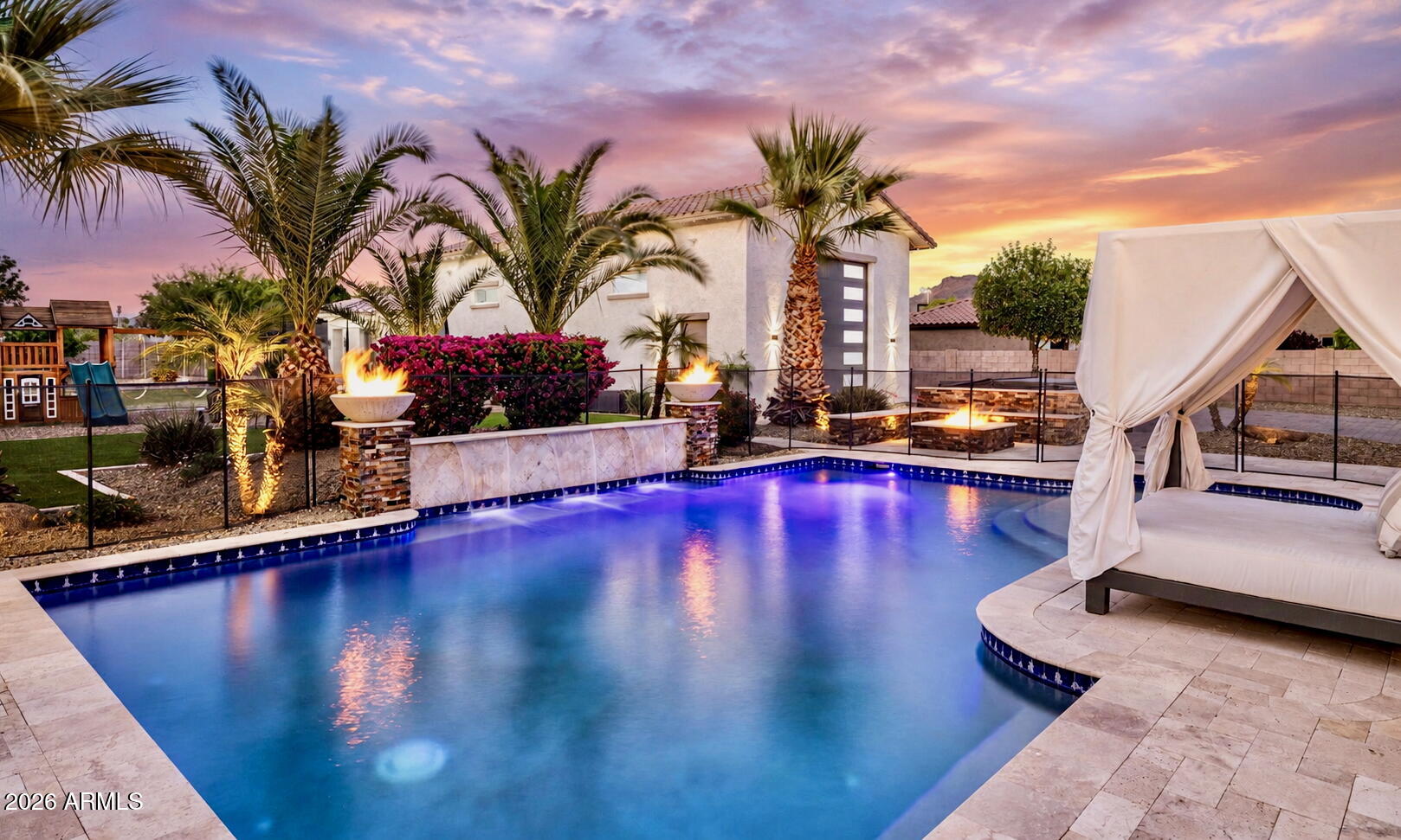 Tucked behind private gates on an expansive lot, this extraordinary custom estate blends luxury, recreation, and resort-style living into one unforgettable property. From the moment you arrive, the striking modern pivot entry door, circular driveway, dramatic front courtyard fireplace, and cascading water feature set the tone for a home designed to impress. Inside, the fully remodeled interior showcases designer finishes throughout, highlighted by an incredible chef's kitchen with a massive 72'' Sub-Zero-style refrigerator, custom pantry, and seamless indoor-outdoor flow through oversized custom sliders in both the family room and primary suite. Entertain effortlessly with a custom wet bar, Control4 smart home integration, surround sound, and multiple gathering spaces designed for both large-scale entertaining and everyday comfort. The backyard rivals a private resort, featuring a newly added pickleball and basketball court, multiple putting greens, over 3,000 square feet of premium artificial turf, lush real grass, mature fruit trees, outdoor kitchen, fire features, multiple ramadas, misting system, and a built-in Bullfrog spa. Car enthusiasts and hobbyists will appreciate the climate-controlled custom garages with lifts, epoxy floors, custom cabinetry, EV chargers, and extensive built-in storage. A detached guest house with full kitchen and laundry adds flexibility for guests, multigenerational living, or extended stays, while the extensive security system, RV amenities, permanent exterior lighting, fully paid solar, and countless custom upgrades make this property as functional as it is stunning. This is more than a home. It's a private luxury compound built for entertaining, relaxing, and living at the highest level.