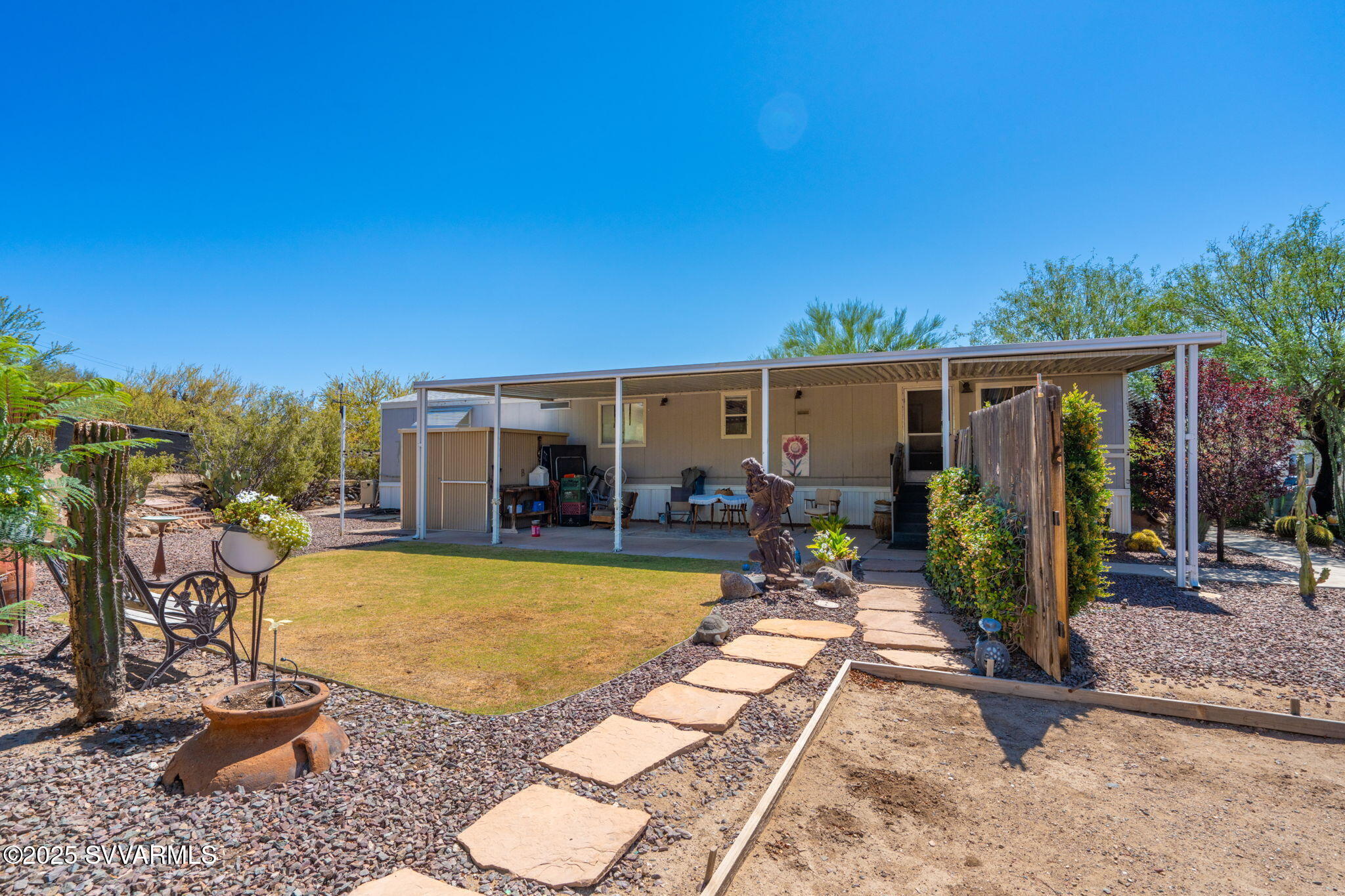 Welcome to your peaceful retreat in scenic Black Canyon City! This well-maintained 2 bed, 2 bath single-wide manufactured home offers the perfect blend of privacy, charm, and space. Situated on a quiet cul-de-sac and boasting incredible landscaping, this unique property spans a total of 0.84 acres with the inclusion of parcel #502-18-040M—ideal for extra space, gardening, or future plans. Step outside and enjoy not one, but TWO covered patios, perfect for relaxing or entertaining. Soak under the stars in your bonus hot tub, or enjoy the Arizona sunshine in your private oasis surrounded by mature trees and a full perimeter fence. Additional highlights include multiple storage sheds, ample parking, and a tranquil atmosphere rarely found. This home is a moved mobile, cash or VA loan apply.