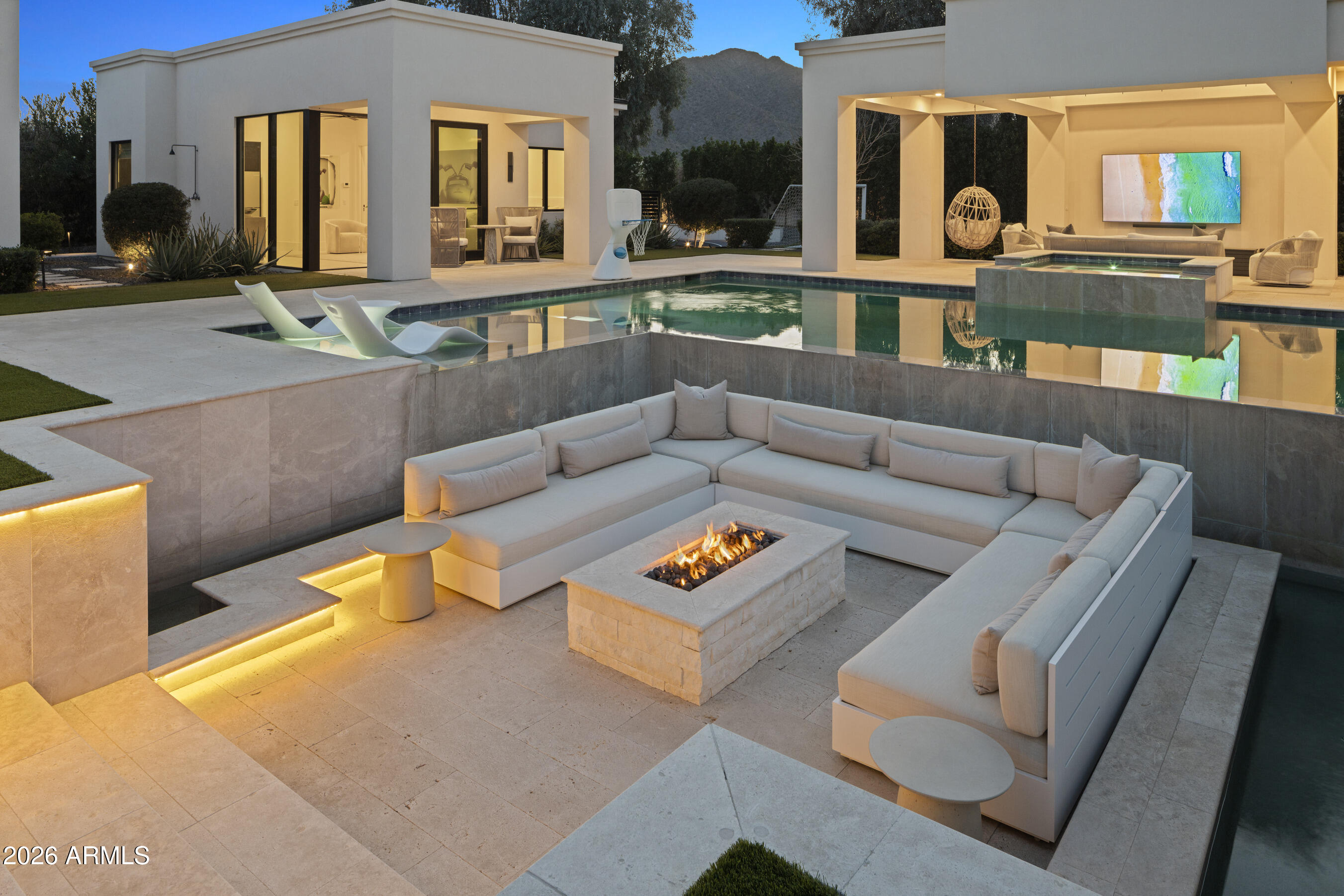 Completed in 2023, this GATED 6-bed, 8-bath estate sits on CASA BLANCA DR, one of Paradise Valley's most exclusive streets! Resort-style grounds feature a large heated pool/spa, sunken firepit, ramada lounge, sport court, putting green, large soccer grass area and BBQ. Statement kitchen w/ oversized marble island and wall of glass cabinetry opens to Great Room, separate GAME ROOM, Bar with serving window + separate THEATER. A curated, design-forward smart home spanning 7,500 sqft, elegant finishes, layered wall treatments, tongue-and-groove oak ceilings, white oak flooring, and architectural lighting throughout. The home has seamless indoor-outdoor living through automated receding walls of glass, an office + FULL CASITA W/ KITCHEN, LIVING RM + LAUNDRY. The primary suite captures CAMELBACK VIEWS with Mica stone wall detailing and 2 spacious closets. Additionally, the home has a 4-car air conditioned garage and a beautiful wine wall in the dining room.