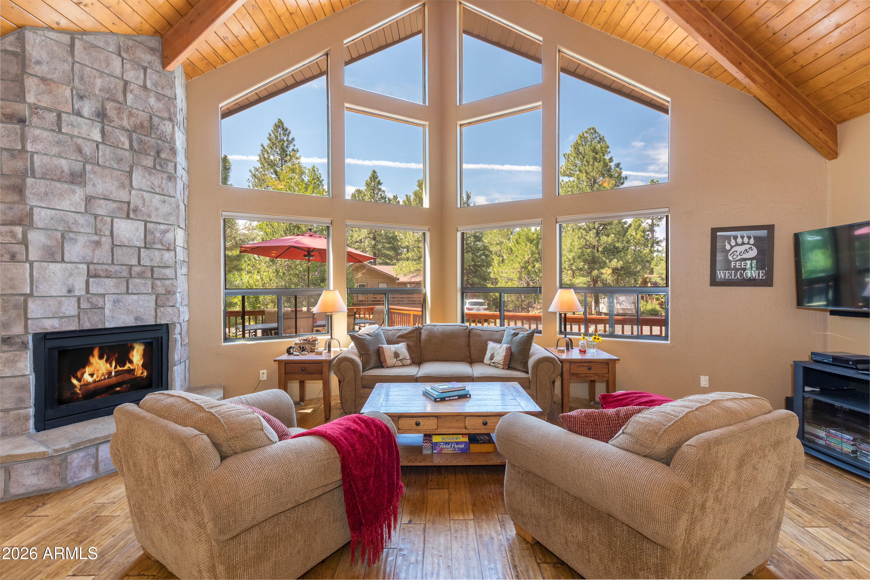 Beautifully maintained and move-in ready cabin on a quiet, tree-lined street in popular Munds Park. Set on a great lot with beautiful curb appeal, mature trees, large boulders, a seasonal spring run-off creek, and open space behind for added privacy, this home offers the perfect mountain getaway or turnkey vacation rental opportunity. The open, light-filled great room features large south-facing dual-pane windows that bring in natural light, forest views, and evening stars. The home offers a desirable layout with the primary bedroom downstairs, plus two bedrooms, a loft/office, and full bathroom upstairs. Tasteful finishes include rustic real-wood floors, granite counters, maple cabinetry, stainless steel appliances, a gas fireplace with stone surround, custom paint, ceiling fans, and a jetted tub in the primary bath. Recent improvements include newer HVAC and appliances, adding comfort and peace of mind. Enjoy outdoor living from the oversized front patio and partially covered wraparound deck with gas grill. Fully furnished and set up as a successful vacation rental, this property is truly turn-key and ready to enjoy from day one.

Munds Park offers incredible year-round recreation with endless hiking trails in the surrounding Coconino National Forest. The private and remodeled Pinewood Country Club (shorter waitlist) offers 18-hole golf, tennis & pickleball, basketball, gorgeous clubhouse & restaurant, fitness center, community lake, playground, kids activity centre and more. Just 90 miles from Phoenix, 20 miles to Flagstaff, 40 miles to Sedona, and about 45 minutes to Snowbowl, this is an easy escape with endless outdoor adventure.