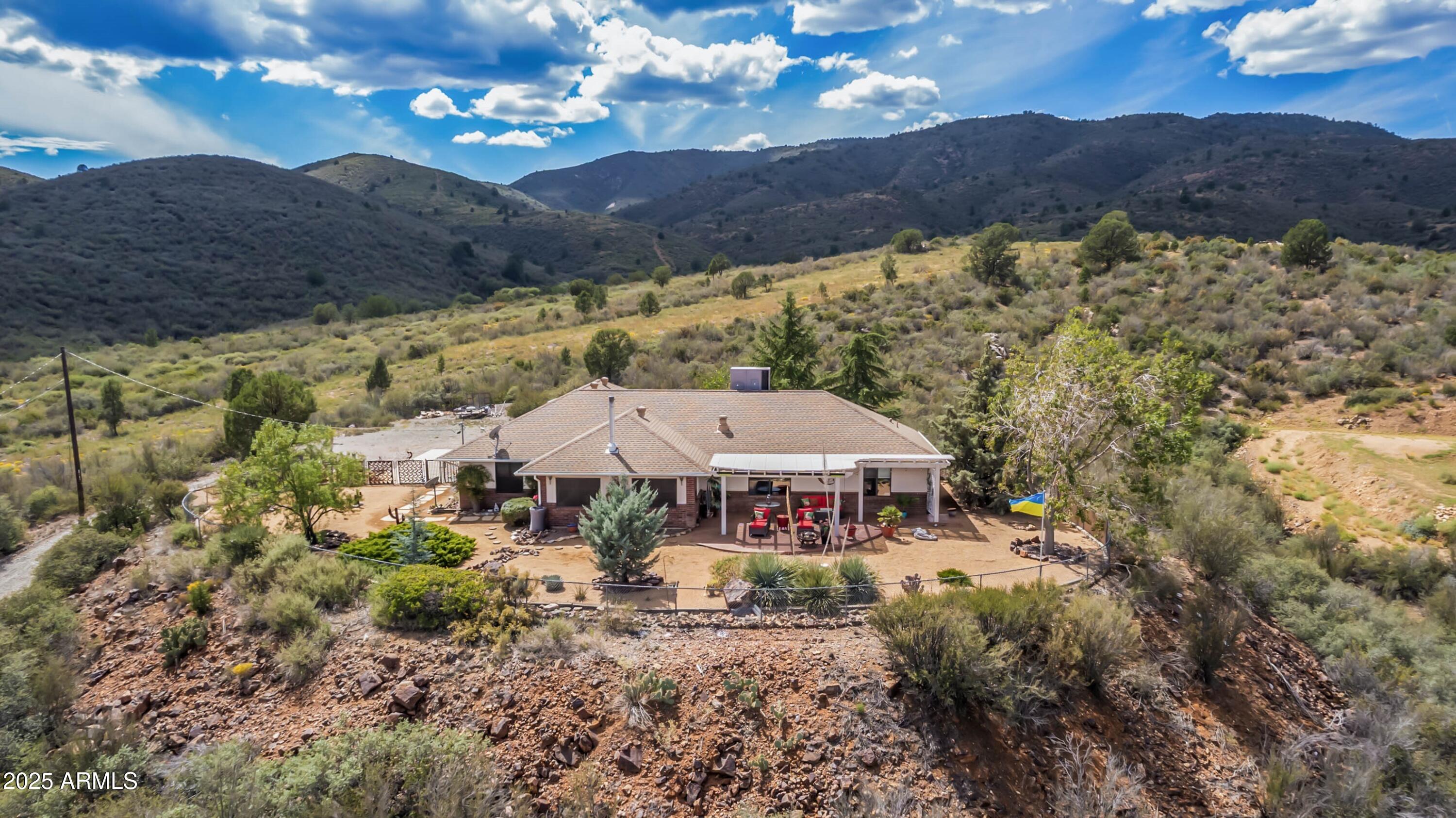 This stunning custom 2300 square foot home sits on a beautiful 4.87-acre ranchette in Dewey and offers breathtaking 360-degree panoramic views. Backing to BLM land and Prescott National Forest. The property is perfect for hiking, biking, horseback riding, and motorsports. The well-appointed three-bedroom, two-bath home features an Arizona room, hot tub, multiple patios, a fenced yard with dog run, and mature trees. Equestrian facilities include a three-stall mare motel, feed and tack shed, and large pen. Additional highlights include an insulated garage with attic storage, owned solar, and paved access just 200 yards from the house. Enjoy country living at its best and only 15 minutes from HWY 69. 36 owned solar panels, you'll appreciate energy savings as you soak in the stunning sunsets from your covered patio. Equestrian enthusiasts will love the 3-stall mare motel & direct access to BLM trails right from your backyard! Nestled in a secluded area, This property is the perfect retreat for those seeking tranquility without sacrificing convenience. Don't miss out on this rare gem! Private Well!
