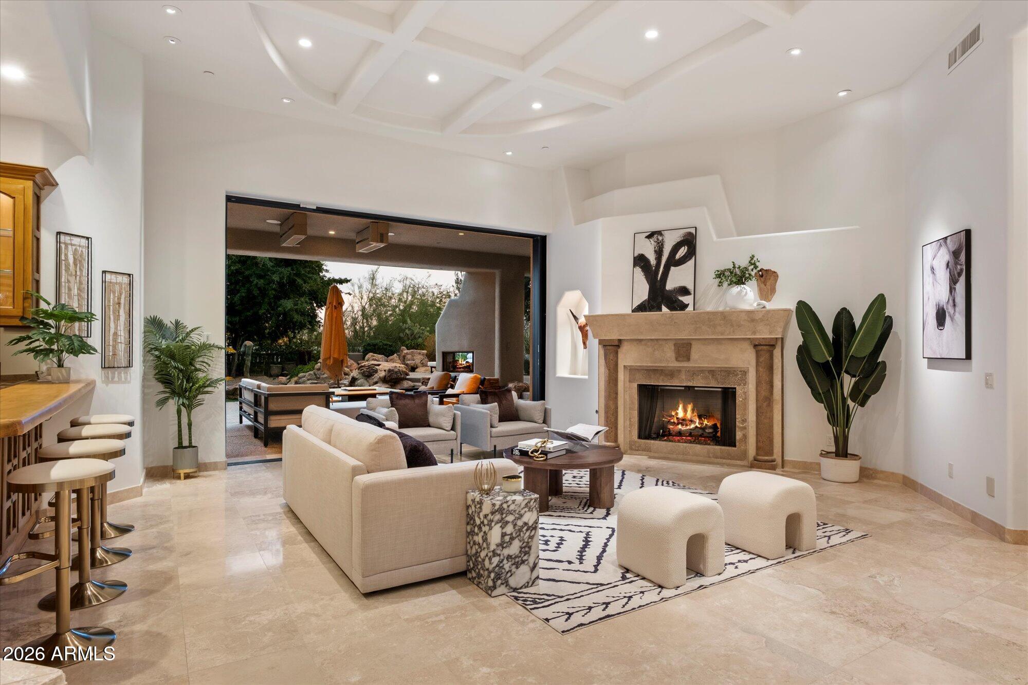 Welcome to an exceptional luxury residence located within the prestigious Desert Highlands, offering 4 en-suite bedrooms plus an en-suite office, 6.5 bathrooms, with an upstairs casita or multi-purpose media room, all thoughtfully designed to deliver refined living in one of North Scottsdale's most sought-after private golf communities. This beautifully appointed home combines timeless architecture with modern livability, surrounded by dramatic mountain scenery and access to world-class amenities, and can be purchased fully furnished. Desert Highlands Golf Club is a private guard-gated community nestled along the iconic Pinnacle Peak mountains. You immediately become a club member after closing (membership dues apply) so you can enjoy the club amenities: golf, tennis, pool, fitness center, exclusive restaurants, and more!
The home makes a striking first impression with a grand entry that opens into the formal living room, where a statement fireplace and automated pocketing sliding glass doors create a seamless indoor-outdoor connection and an immediate sense of scale and sophistication. And not to be overlooked is the full bar for unforgettable experiences! Natural light fills the space, setting the tone for both everyday comfort and effortless entertaining. 
At the heart of the home, the kitchen anchors the living spaces and is designed to accommodate both daily living and hosting with ease. It features an oversized center island, two dishwashers, granite countertops, abundant high-quality cabinetry, and a kitchen window that frames beautiful Pinnacle Peak views. The family room and dining room are directly adjacent to the kitchen, creating a true great room experience that reflects what home buyers look for and how people live and entertain today.
The floor plan offers four en-suite bedrooms plus a dedicated en-suite office and a total of 6.5 bathrooms, providing privacy, flexibility, and excellent separation of space. The primary suite is thoughtfully split from the remaining bedrooms and serves as a private retreat, featuring a spacious bedroom with its own fireplace, private patio access, a his and her bathrooms with a shared central shower, and two expansive walk-in closets designed to delight anyone who values organization and wardrobe space. The office includes its own bathroom and closet, making it highly versatile and suitable for a variety of uses beyond a traditional workspace.
An upstairs casita or multi-purpose media room adds another layer of flexibility and opens to a balcony with distant city-light and Pinnacle Peak views, creating an ideal setting for evening relaxation or entertaining.
Desert Highlands Golf Club is a private community nestled among the mountains of North Scottsdale. An immediate golf membership is available at closing, a highly desirable benefit within Desert Highlands. (Buyer to pay applicable membership initiation and transfer fees at closing.) The club allows members to build camaraderie as neighbors and friends through shared experiences on the golf course, at the racquet club, in the fitness center, by the pool, or while dining at one of their exclusive restaurants. When you buy a luxury home in Desert Highlands, you're investing in more than real estate; you're investing in yourself.