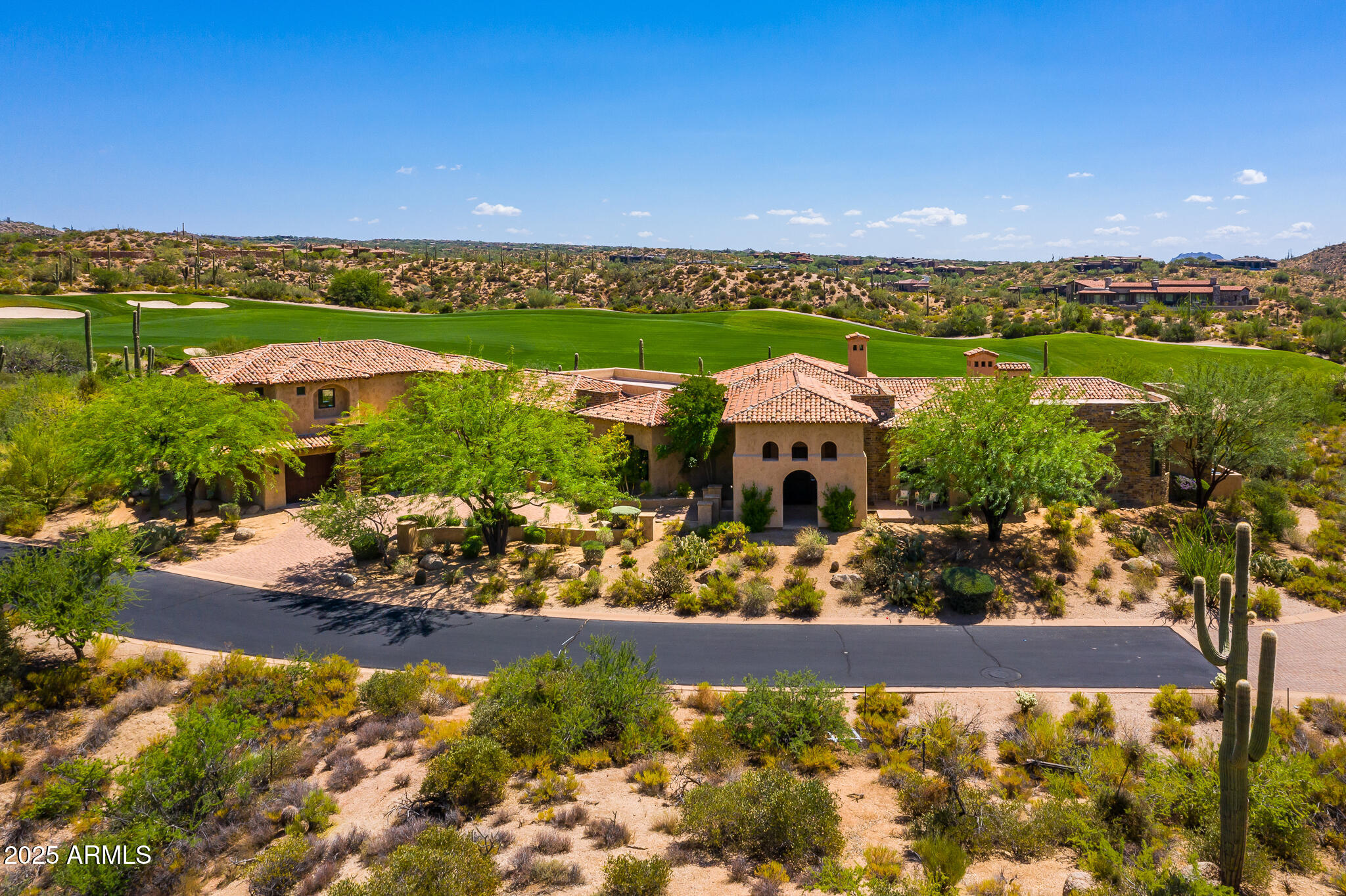 Perfectly positioned on a quiet cul-de-sac in the prestigious Saguaro Forest Village of Desert Mountain, this stunning Mediterranean-style estate with a Golf Membership available, offers timeless elegance, exceptional craftsmanship, and sweeping panoramic views from every room. Overlooking the 13th fairway of Chiricahua Golf Course with commanding vistas of Apache Peak and the surrounding mountains, this residence captures the very essence of luxury desert living. Crafted with exquisite attention to detail, the home is a masterpiece of quality and design. Rich stonework, chipped-edge travertine flooring, intricate beamed ceiling treatments, fine millwork, and granite countertops reflect the thoughtful craftsmanship found throughout. The spacious main level features a warm and inviting great room, formal dining area, chef's kitchen, private library, and three ensuite bedroomseach offering privacy and access to spectacular views. The heart of the home, the kitchen, is beautifully appointed with top-tier appliances, ample prep space, and a butler's pantry ideal for entertaining.
The magnificent primary suite serves as a private retreat, complete with its own exercise room, coffee bar, luxurious bath, and a generously sized custom closet with a secondary laundry area for convenience. Additional highlights include a climate-controlled wine cellar, a beautifully finished upper-level casita with its own living area, full kitchen, and view balconyperfect for guests or multigenerational living. Outdoors, enjoy multiple terraces and patios, including a handsome covered entry and intimate sunset patioideal for enjoying the serenity and natural beauty of the Sonoran Desert. An oversized 3-car garage and expansive auto court provide ample parking and storage for guests and vehicles. Located within the highly sought-after guard-gated community of Desert Mountain. This is an extraordinary opportunity to own a one-of-a-kind residence in one of Scottsdale's most coveted golf communities.