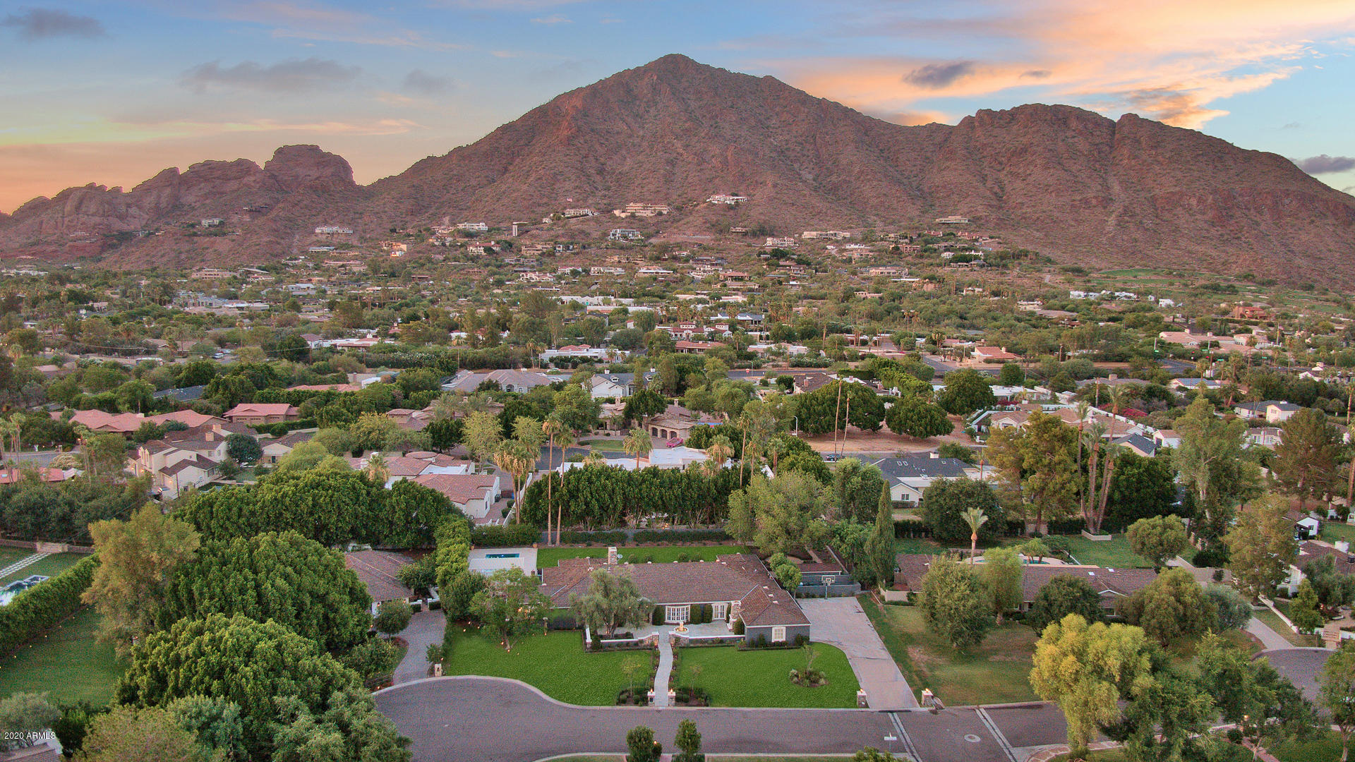 Stunningly updated, this luxuriously laidback ranch-style home is nestled on a quiet double cul-de-sac deep inside Arcadia, one of the most coveted communities in Phoenix. Front: Expansive grassy-green lawn, towering palm trees, flower-lined walkway, fireplaced courtyard. Inside: Elegant parlor-like formal rooms w/big windows. Spacious chef's kitchen w/built-in custom China closet, professional-quality Viking gas range trimmed w/Italian-esque aged-brick-like accents. Family room w/quartet of French patio exits, well-appointed entertainer's wet bar. Romantic master retreat. Executive office/den/library. Connected guest/in-law suite w/bath, kitchenette. Rear grounds: Very lush and private w/shimmering diving pool, gazebo, emerald-hued lawn, mature citrus, generous patios, BBQ island, Camelback Mountain views. Lots of room for additional personalized alfresco amenities. Also: Three-car garage plus plenty of guest parking. 5BD/6BA/5,217SF.