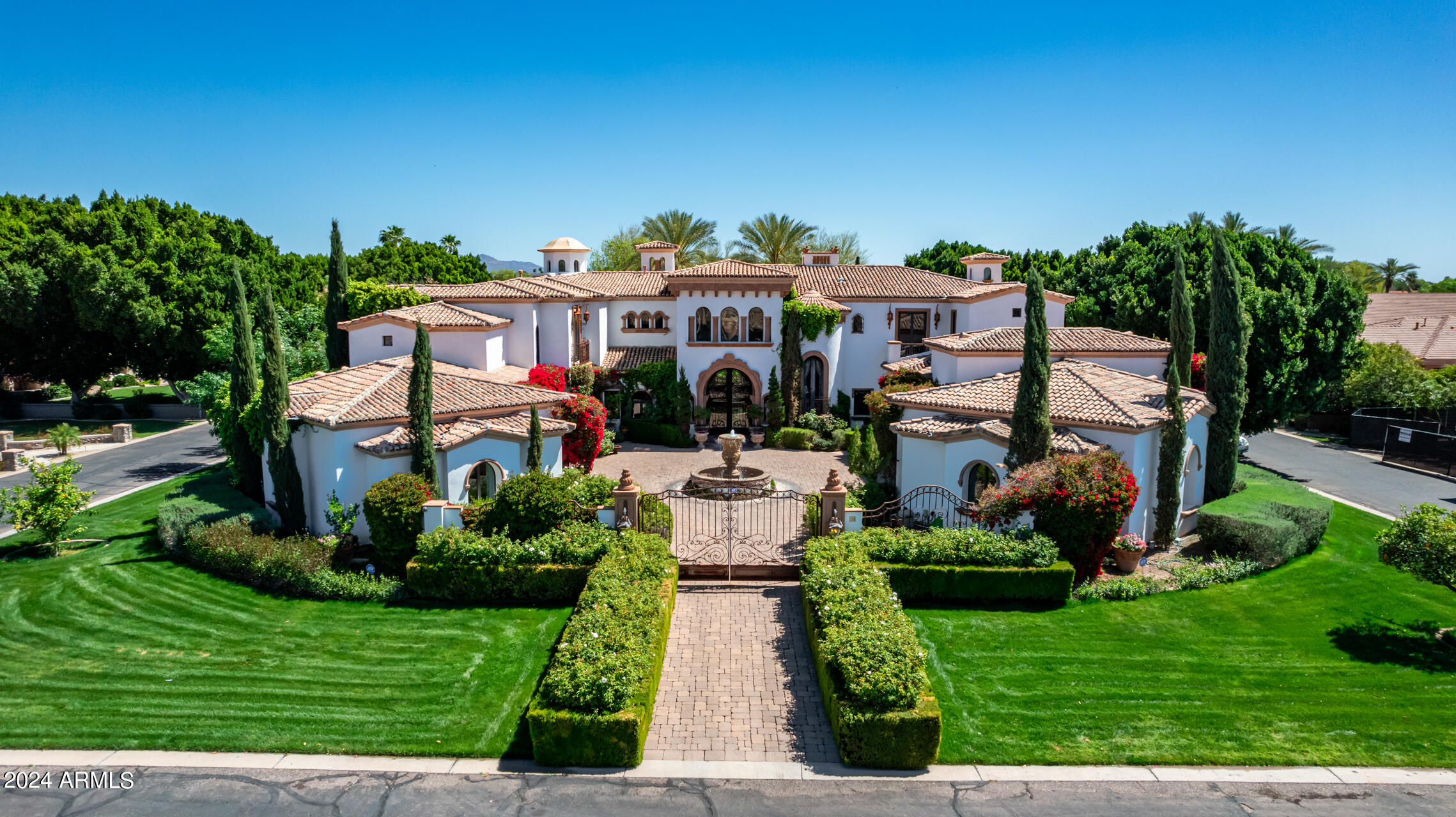 UNBELIEVABLE OPPORTUNITY! ONLY $418.59 per square foot - FURNISHED! This is a must experience gated Mediterranean estate situated on a secluded lot in the gated community of El Portillo. This is an entertainer's dream designed for resort-syle living. Drive through the rosebush hedges and a grand gate will welcome you to the motor courtyard where you'll find yourself on vacation in a beautiful foreign country.  The sights, the sounds and the smells are heavenly.  After you tour the fountain and flower gardens and make your way to the grand entry, you will be welcomed into a gorgeous foyer with 20+' ceilings, a grand staircase and a formal living room built for a king with views of the majestic backyard which has over 1200 sq ft of covered patios, a gorgeous fountain that... trails down to the playful grass area, a lush formally landscaped sanctuary with an all tile pool, a large ramada with sitting area, outdoor fireplace and other fun features! Plan weddings, proms, graduations, business meetings or neighborly get-togethers in this completely private tree lined private estate.  

Inside you will find 14,322 square feet of pure luxury.  The main floor has the Majesty's bedroom with a hand carved cantera fireplace, a large luxurious bathroom and access to a private patio and even has a banana tree.  Nearby is a stately wood encased den/library and access to 4 of the 9 car garages. The formal living room is magnificent with hand painted ceilings, hand-carved cantera stone pillars & fireplace, custom made furnishings with room for a grand piano. Around the corner is a chef's kitchen and dining room that is elegant and complete with ambient fireplace and incredible ceilings and cabinetry detail, a large stone covered island, two Miele dishwashers, two built in ovens, two warming drawers, newer Dacor gas cooktop, two microwaves and built-in fridge/freezer. The formal dining room with its own ice maker, cabinetry and pantry, is adjacent to the built-in barbecue and "Little Italy" lushly landscaped private patio with party lights. The main level also includes a large family room, a giant game room, pool bath, and large exercise room off the patio.  Don't miss the 15 person home theater with AMC like acoustics and electronics! The owner recently paid nearly $1m for electronics, sound and security systems throughout the home!  

Upstairs you will enter into a grand ballroom-like game room/second family room with an adult engineered slide where you can quickly meander and slide down to the first floor's game room and patio.  The second floor is enchanted with hotel-like amenities - including a 2nd romantic primary bedroom with two sitting rooms, fireplace and picturesque balcony.  The primary bath is fit for a queen with large mirrored vanities, a jet tub big enough for two, a beautiful see through shower with many shower heads and body sprays, not to mention the glass lined cabinets in the walk-in closets w/ a convenient stackable washer & dryer. With its spaciousness, high ceilings, and gorgeously appointed detail, it feels like a spa retreat. 

There are a total of 7 bedrooms (5 master suites including sitting areas, walk-in closets and grand en-suite bathrooms). There are numerous balconies on the second level all with great views of the stately yard and when doors or windows are open you can listen to the water splashing in the fountains or music playing inside and out.  

The backyard has plenty of areas to entertain, and the owner has hosted parties with over 400 guests. 7 Energy-Efficient HVAC Systems all less than 3 years old and newer Ruud energy efficient Water Heaters. This is the only lot in the community that has no neighbors boarding their lot. It is a gated private estate inside a gated luxury neighborhood.  The backyard has its own private gate to directly access the community tennis court, basketball court and park area. 

Don't miss this opportunity of a lifetime - homes like this are 2 to 4 times more expensive in Scottsdale or Paradise Valley.