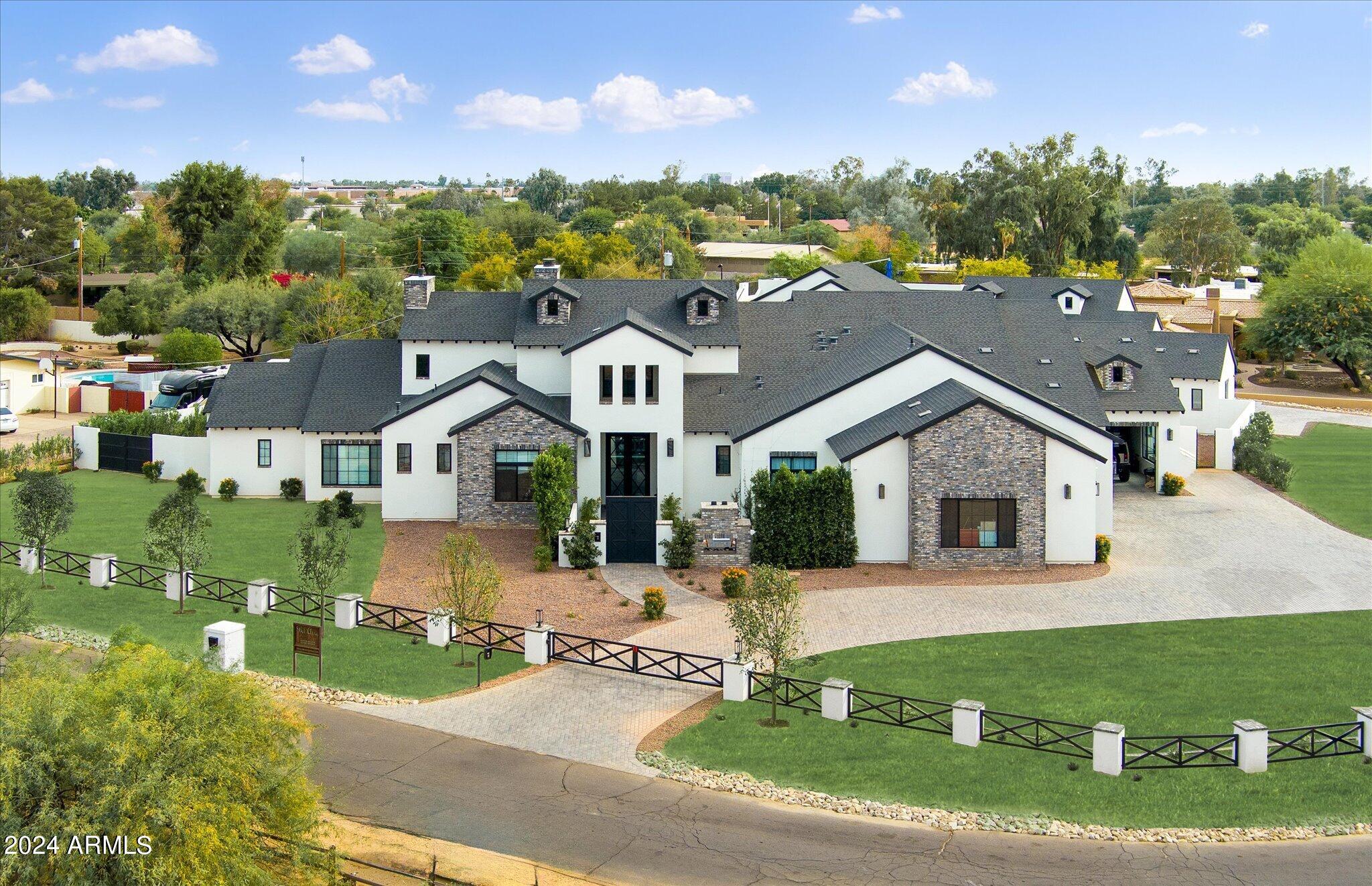 Welcome to the ultimate car collector home in the heart of Scottsdale w/ NO HOA on 1+ acre. This privately gated new construction home has everything for him, for her, the kids, and guests. The over 80' deep RV garage/man cave has a full kitchen and bath, metallic epoxy floors, room for 20+ cars, and media area w/ 165'' projector screen. This 8,485sf home features a main house w/ 5-bedrooms, 5.5 bathrooms and a detached guest house w/ full kitchen, living room, laundry, garage, and private entrance -- all in addition to the RV garage. The primary suite features a spa-like bath and large designer closet. Entertain family and guests in the backyard w/ a sports court, pool w/ oversized Baja shelf, spa, splash pad, view deck w/ bar + grill, large covered patio w/ fireplace and outdoor kitchen Enter the foyer with marble floors and soaring ceilings where your eye is drawn through the formal living room with masonry fireplace and formal dining room, to views through the pocketing glass doors over the covered patio space with two-way fireplace and an impressive backyard. A temperature controlled 960-bottle wine cellar with marble tiled walls and flooring is a statement piece in this room. Enter the chef's kitchen with oversized pantry and "Costco door", double Quartzite islands with sit up seating with top of the line applicable with a Wolf gas stove + oven, double wall ovens with warming drawer, Sub Zero refrigerator and freezer, double dishwashers, beverage coolers, and rose gold Brizo fixtures with eye-catching lighting. The kitchen overlooks the family room with masonry fireplace and abuts the formal bar with ice maker, mini fridge and sit-up bar seating. Enjoy al fresco dining in the breakfast nook with 90-degree retractable glass walls overlooking the backyard. Off the family room you'll be taken to a flex room ideal for kids to play, along with two additional en-suite guest bedrooms.

Enter the master suite with a cozy fireplace on a statement wall of marble and retractable glass walls leading you to an outdoor patio. The primary bath was built with a spa in mind showcasing polished Manhattan marble flooring, makeup bar, double sinks, his and hers rain showers (one a steam shower) with rose gold Brizo features and detailed herringbone marble tile work for the most discerning eye. Relax from a long day in the stand up tub perfectly positioned to enjoy fresh Arizona air through the retractable glass walls with private patio, masonry fireplace, and outdoor TV. Impressive is an understatement when it comes to the wrap-around designer closet with glass fronted doors, backlit lighting, dressing room, its own sitting room, as well as its own laundry. This closet was designed to showcase and keep safe all of your luxury belongings. 

Host your guests in the detached guest house with a full kitchen with gas range, living room, bedroom, bathroom, laundry, and garage space with a private backyard for the guest house. Guest house utilities can be separated from the main house.

Don't miss this truly unique estate in the heart of Scottsdale with close proximity to HWY 101, Old Town Scottsdale, Kierland Commons, Scottsdale Quarter, Paradise Valley, and endless golf courses.

- MAIN HOME GARAGE DIMENSIONS: Garage doors are 10' high with 12' ceilings allowing room for lifts in all bays.
- RV GARAGE DIMENSIONS: RV garage door is 14' high x 12' wide with 16' ceilings.
