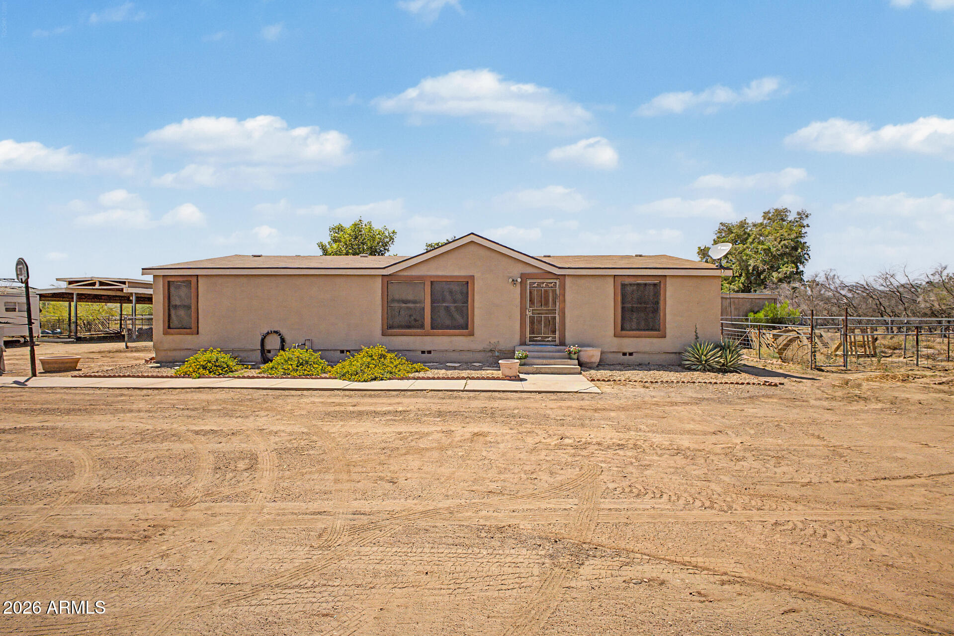 Welcome to this manufactured home on desirable horse property! With East/West exposure & a setting along unpaved roads, this property delivers privacy, open skies, & room to roam. Inside, you'll find a warm interior featuring a mix of tile & wood flooring, dual-pane windows, & a brand new A/C system. The cozy family room provides a space to relax, while the kitchen has laminate counters, a breakfast bar, & a charming breakfast nook. Split main bedroom offers a well-appointed bathroom with dual sinks & a walk-in closet. Additional features, such as baseboard heating, enhance the home's functionality! Enjoy a grassy backyard with a covered patio, an RV gate, an RV hookup, ample storage space, & updated septic system. Horse enthusiasts will appreciate the dedicated stall & arena! Must see!