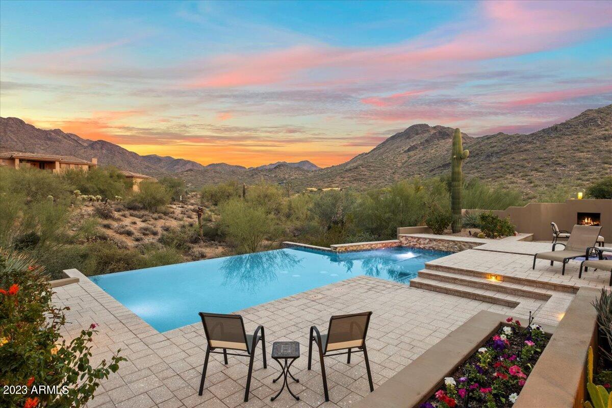 Nestled in the prestigious Canyon Heights neighborhood, this custom 5,919 square foot residence offers a luxurious and thoughtfully designed living space on a generous 2.199-acre lot, providing privacy and breathtaking panoramic views of the McDowell mountains. Upon entering, the residence showcases high-end finishes with a neutral palette that complements the tranquil surroundings. Throughout the home, travertine floors and granite countertops add a touch of sophistication. The highly functional kitchen is outfitted with an enormous Subzero refrigerator and freezer, a Viking gas range, Dacor double ovens, and island with a second sink and a walk-in pantry. The primary bedroom suite, strategically situated for privacy, boasts a spacious walk-in closet and a en suite bathroom that is nothing short of a spa retreat. This spa-like oasis includes two toilet rooms, two separate vanities, a jacuzzi tub, and a walk-in shower.
Ascend to the upper level to find a second primary suite, accompanied by a loft and two view decks, offering an elevated perspective of the stunning mountain vistas. Two additional guest bedrooms, each with en suite bathrooms and walk-in closets, provide comfort and convenience for family or guests and are located on the main level. A flexible space awaits creative use, whether it's envisioned as a theater room, fitness room, or a dedicated home office. With four gas fireplaces strategically placed throughout the home, warmth and ambiance are abundant. The oversized 3-car garage comes equipped with built-in cabinetry, providing ample storage space for convenience.
Step outside to the expansive covered patio overlooking a heated negative edge swimming pool and spa. This outdoor oasis invites relaxation and unwinding while enjoying the majestic mountain views that surround the property. 
This meticulously maintained Canyon Heights home combines desert serenity with city convenience. Just minutes from North Scottsdale's best dining and shopping, it is a rare find in a prime location.

Additional features and amenities include: 
- Spacious laundry room located on main level
- Washer/Dryer hookups in primary closet
- Outdoor Shower
- Heaters on Patio
- HVAC units were replaced in 2016
- Hot water heaters were replaced in 2018
- Wireless pool/spa controls