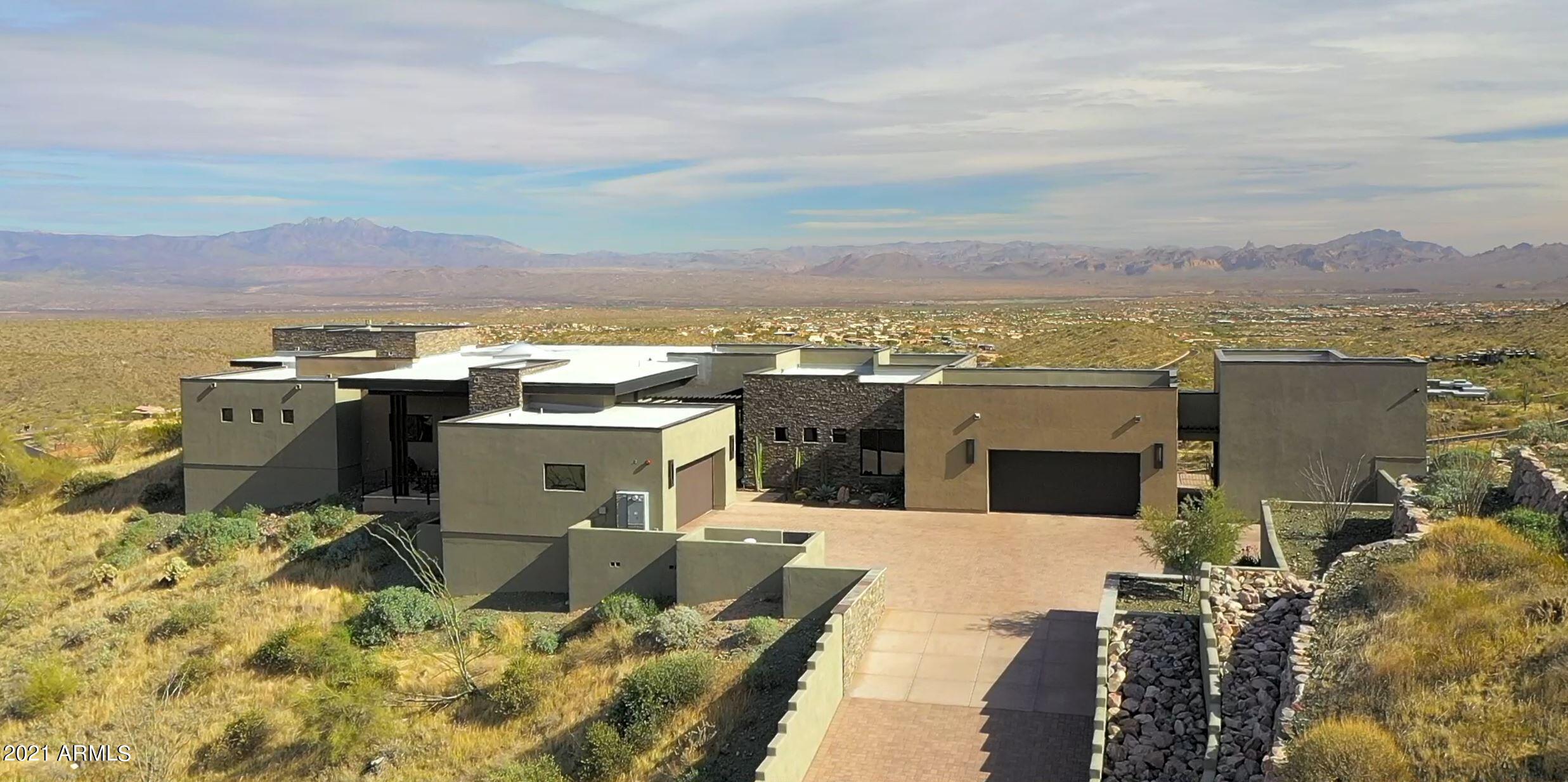 Exquisite craftsmanship and unique design with STUNNING VIEWS in all directions makes this single level soft southwest contemporary home at the top of Eagles Nest a desert gem. Several outdoor entertaining areas, tile flooring throughout, all cabinetry by Affinity Kitchens. Great room style living area offers huge kitchen with multi-level granite counter, Thermador appliances, huge walk-in-pantry. Large dining area with private patio and McDowell Mountain views. Great room with sliding pocket doors to offer indoor/outdoor living with Four Peaks and city lights views. Retractable TV screen, gas fireplace, and bar. Control 4 security, home theater automation. Split master floorplan with 2-way FP to sitting room, barn door entry, elegant bath with large soaking tub and walk-through shower. Secondary living area at other end of the home, two en-suite bedrooms and exit to casita with a private paver patio, steel railing and steel trellis along with a gate to access the back yard. Dixie Mine trailhead is located at the main entrance to the community at the guard gate.  Via it, you can access the McDowell Mountain Preserve, Fountain Hills trail system and the Scottsdale trail system.


Designed by Steven Brenden and built by Sandella Custom Homes, this contemporary masterpiece offers a mountaintop location with great privacy and massive panoramic views.