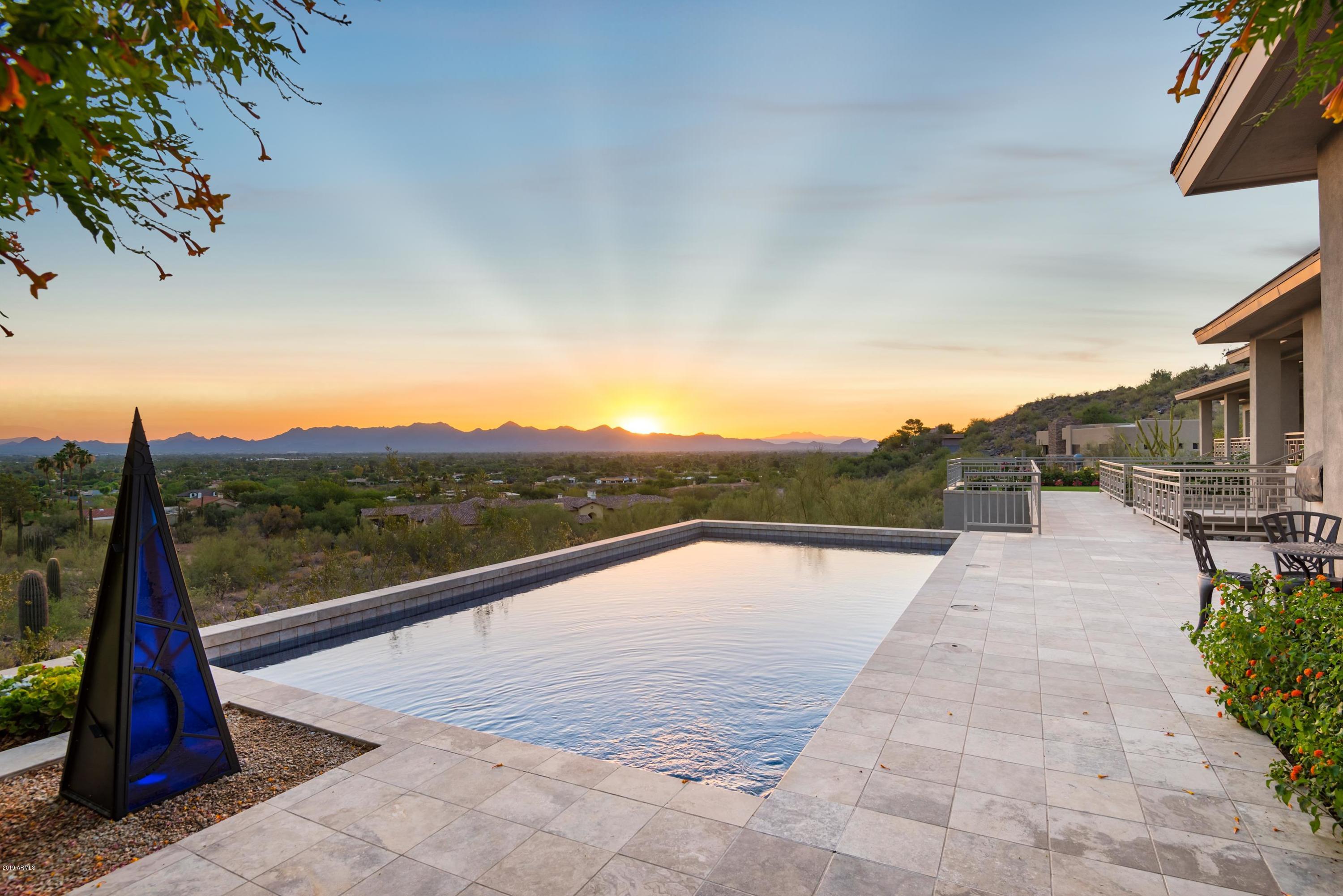 MODERN TRANSITIONAL ESTATE ALL ON ONE LEVEL with NO INTERIOR STEPS & ALL HIGH CEILINGS- carved into the North slope of Mummy Mountain and taking full advantage of UNOBSTRUCTED VIEWS of Paradise Valley and beyond. The Master Suite features a sitting room, gas fireplace, stunning views, a huge Master Bathroom with heated floors, his & her closets, a garden room with secondary laundry and a private courtyard - in addition to an adjoining en suite exercise room/bedroom. All other bedrooms are en suite as well, 800 bottle temperature controlled wine, media room, and a private library/office adorned by sumptuous Cherry wood walls and ceiling. Separate Guest Casita, with attached garage (4 Car in total), living room, and kitchenette. Too many upgrades and features to list - its a MUST SEE!
