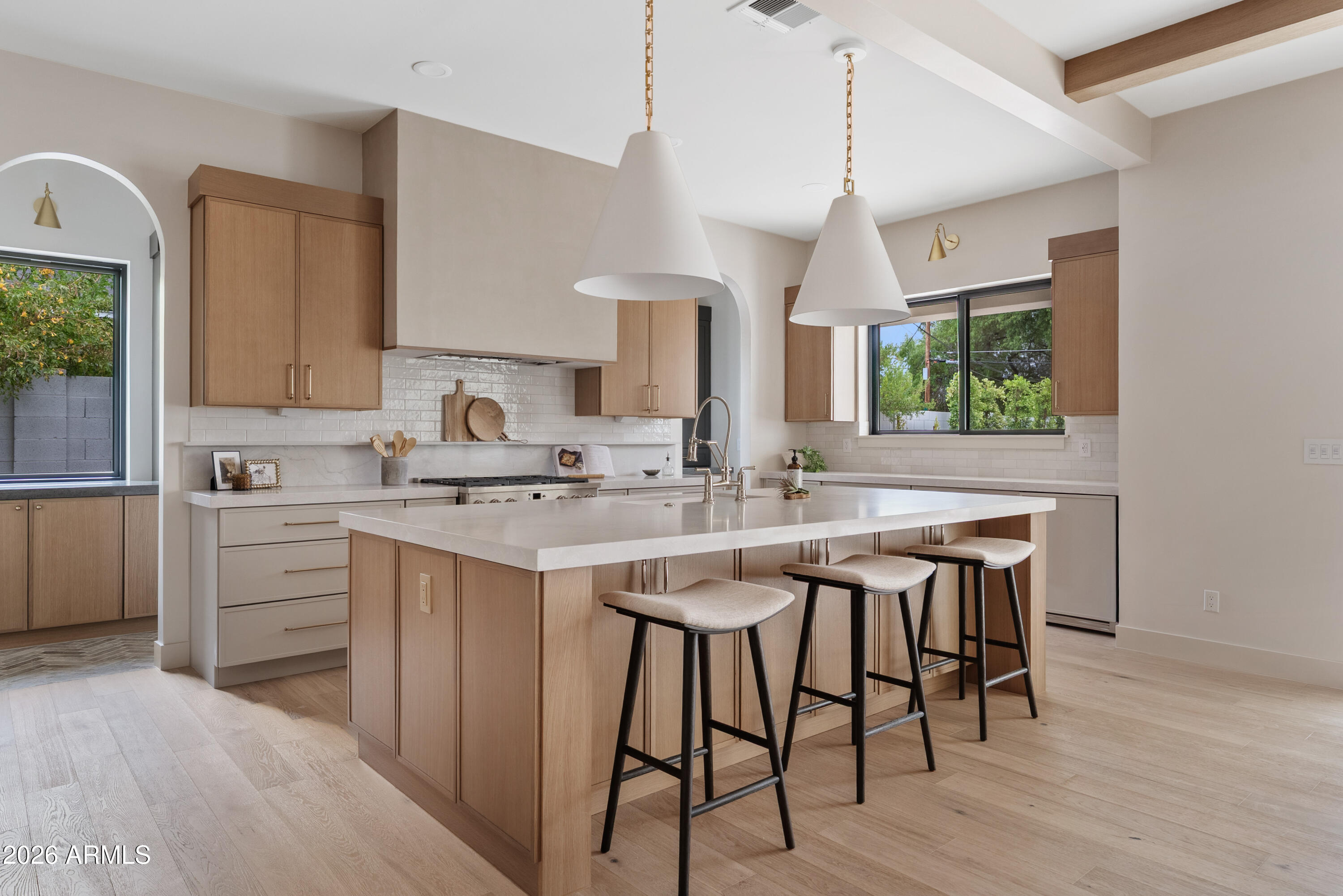 Brand-new, all on one level, and finished like someone planned to stay. Set on an oversized 1/3-acre lot in the Arcadia Osborn pocket, this brand-new single-level home spans over 3500 sq ft: 4 bedrooms plus a dedicated office, 3.5 baths, an oversized 2-car garage, and a private pool. The 900+ sq ft primary suite is the showstopper: pool views, a designer's dream bathroom and a 200+ sq ft closet with custom built-ins and a center island. The kitchen stuns with stained oak cabinetry and a wraparound pantry tucked behind it. Features like custom steel-and-glass office doors, stained wood ceiling beams and decorative wall molding give the home real craftsmanship. Large secondary bedrooms with walk-in closets mean everyone gets ample space. Outside, all-new landscaping wraps the pool in travertine pavers and turf, with lush sod and plants in front and back. Minutes from LGO, Postino, and all the Arcadia hotspots.