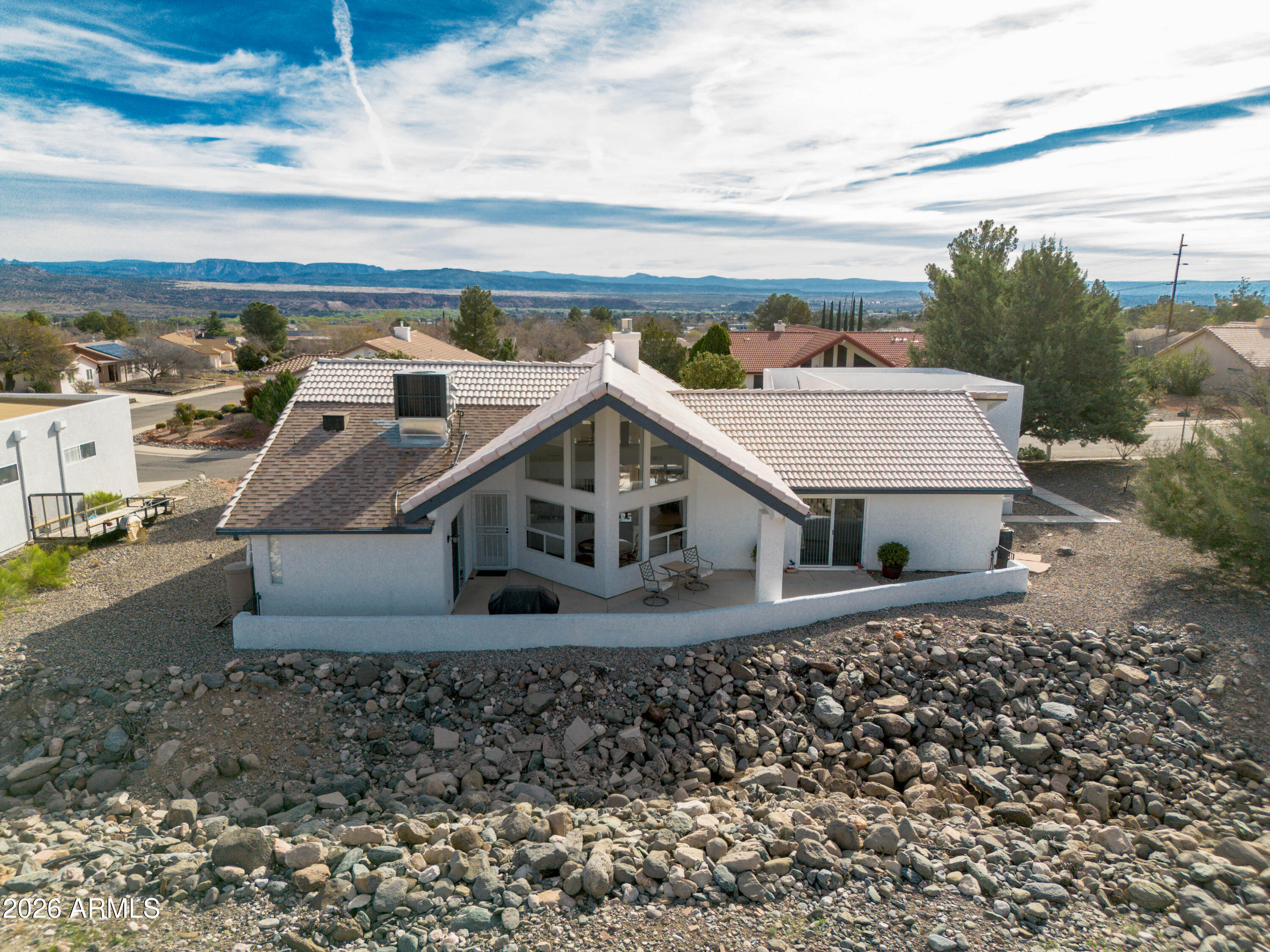 Elevated desert living with panoramic views in desirable Mingus View Estates! Tucked at the end of a quiet cul-de-sac, this thoughtfully updated single-level home offers a low-maintenance, lock-and-leave lifestyle with minimal exterior upkeep. Enjoy breathtaking Red Rock sunsets from the front patio and Mingus Mountain views from the back patio and upper observation deck. Vaulted ceilings, abundant natural light, and an open floor plan create a welcoming atmosphere. The split-bedroom layout provides privacy, with each bedroom offering direct outdoor access. The updated kitchen features granite countertops, modern appliances, and expanded pantry storage. Newer HVAC and water heater. Conveniently located near Arizona Wine Country, Sedona, dining, shopping, and medical services.