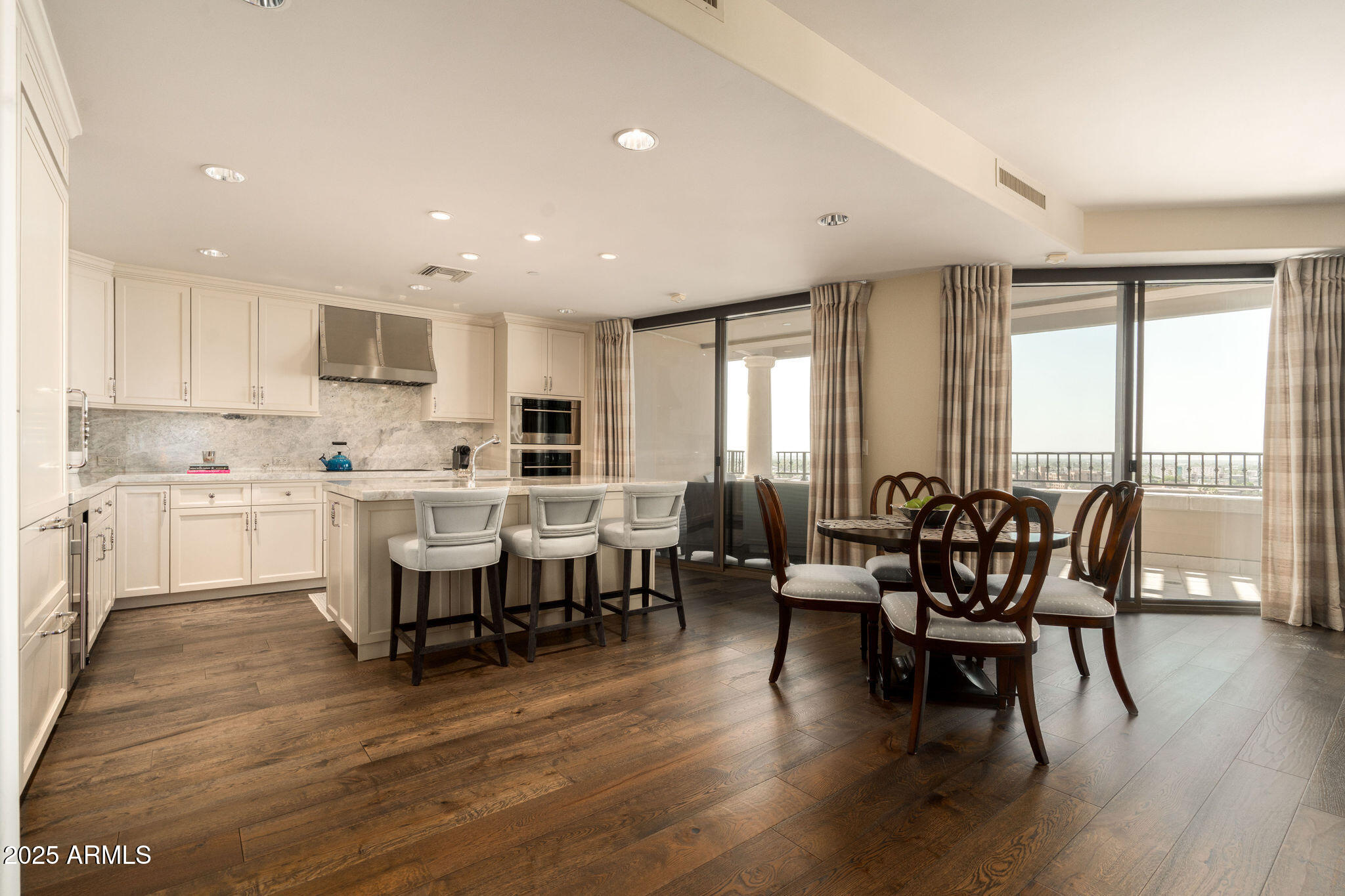 Experience elevated luxury living in the heart of Old Town Scottsdale from this exquisite 11th floor residence in the prestigious Scottsdale Waterfront. (*note: the 11th floor of the Scottsdale Waterfront picks up one extra foot of ceiling height, making it the same as the penthouse) This beautifully remodeled ''P'' floor plan overlooks the southern views of city lights and the canal below rarely becomes available at the Waterfront. 2 spacious en-suites, 2.5 bathrooms, an open den that has a custom built in desk, and large walk in closets in bedrooms. City lights are from each room in the home. The kitchen and main living area underwent a sophisticated remodel, by Toronto Interiors, showcasing Quartzite countertops and backsplash, custom cabinetry, a Wolf gas range and Wolf oven, and a Sub Zero refrigerator, wine refrigerator, and rich hardwood flooring. In the spacious primary suite, the bathroom was thoughtfully redesigned with an over-sized walk-in marble shower, and a dedicated makeup vanity. Rohl polished nickel plumbing fixtures, luxury wall coverings and romantic lighting adds to the elegance of the home.  Smart home features and motorized shades are throughout the living area & primary suite perfectly blending style and function. The powder room offers refined elegance with custom vanity, Rohl polished nickel fixtures, and designer wall coverings. Every detail reflects timeless craftsmanship and meticulous care. Enjoy access to premium community amenities including concierge services, fitness center, rooftop pool and spa, club room, and secure underground parking, and valet. Featuring 2 parking spaces on the first floor, and a storage unit.  All just steps from the best shopping, dining, and walking paths along the canal.