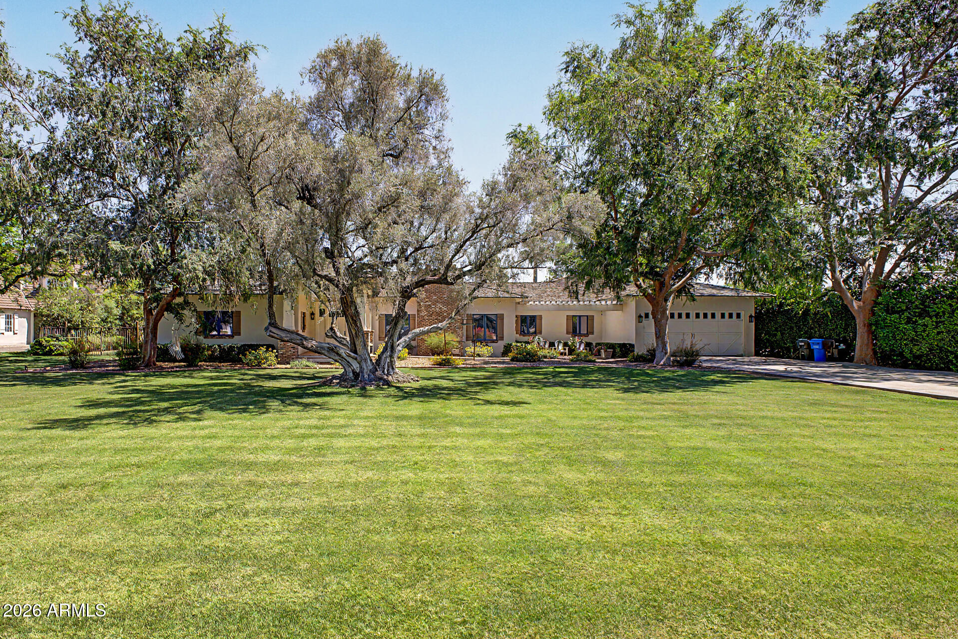 Exceptional home set on an expansive lot in the highly desirable North Central Corridor! Spanning 5,000 sqft, this meticulously maintained residence offers resort-like amenities & timeless curb appeal. Beautifully landscaped front yard, covered porch, front patio, and a 4-car garage with an extended driveway welcome you upon arrival. Inside, a thoughtfully remodeled interior blends classic architectural details with a modern floor plan. The living room features a wood-burning fireplace, creating a warm and intimate atmosphere, while the expansive great room flows effortlessly between spaces. Family room with its own fireplace, gourmet kitchen, hardwood flooring, and multi-panel sliding glass doors that open to the backyard are attributes that can't be left unsaid. The owner's suite is a true retreat, complete with a fireplace and a lavish en suite bathroom. Attached casita with full kitchen offers flexible space for guests or multigenerational living. Spectacular backyard offers a sparkling pool, built-in BBQ, multiple travertine patios, batting cage, putting green, and a tennis court. Conveniently located near shopping and dining. The stunning gem truly has it ALL! A property of this caliber must be experienced in person. Act now!