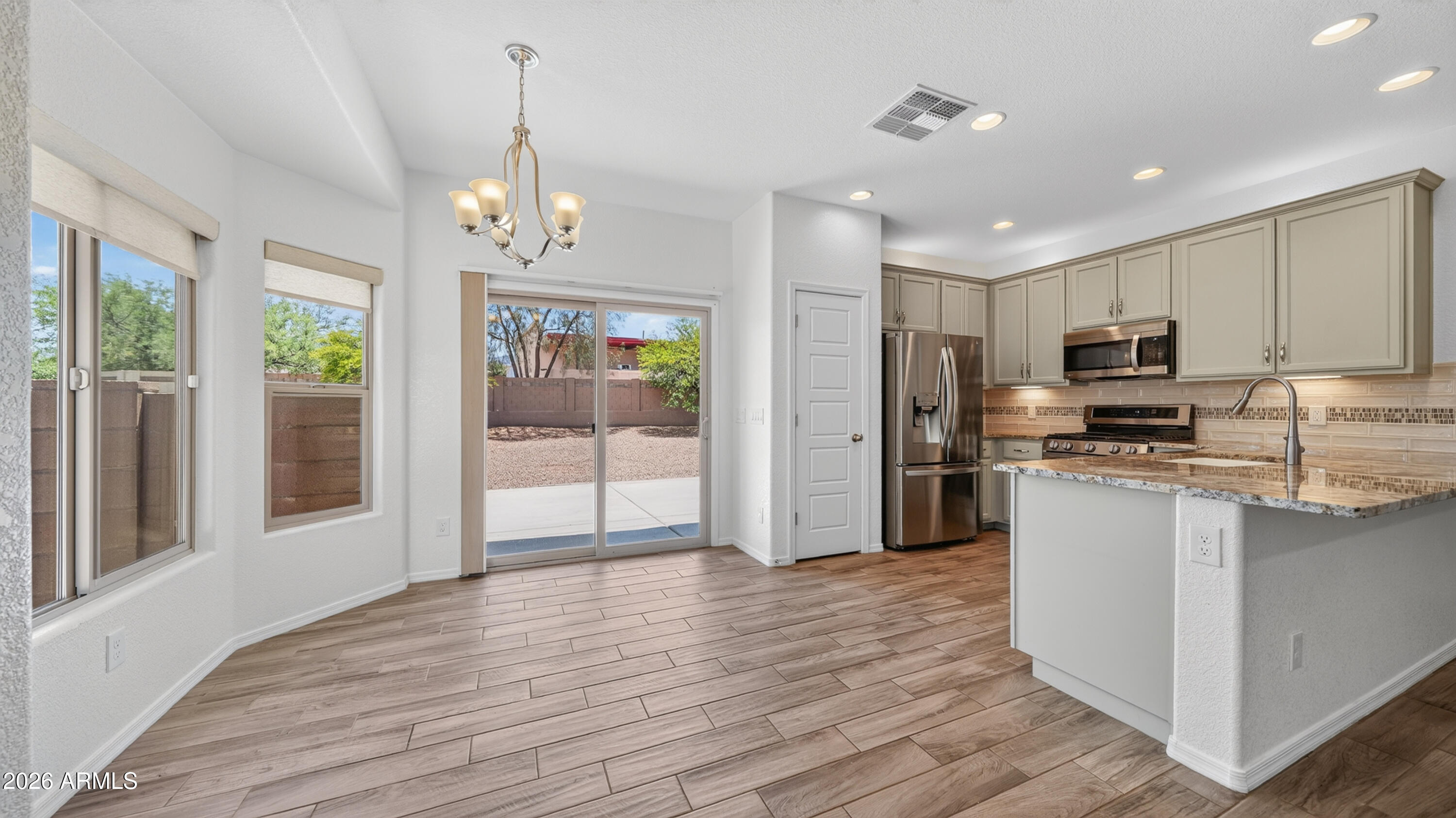 Beautiful move-in ready home with a spacious backyard perfect for relaxing or entertaining. The kitchen features granite countertops, 42'' alder wood cabinets with over/under cabinet lighting, a custom backsplash, and LG stainless steel appliances including the refrigerator.

Enjoy upgraded wood-look tile, comfortable carpeted bedrooms, a pre-plumbed soft water loop, and fiber optic wiring for high-speed connectivity. Step outside to the extended patio slab, already plumbed with gas for a BBQ setup or fire pit -- the perfect place to enjoy Arizona evenings.

Located in a community packed with amenities including 3 pools, hot tub, fitness center, clubhouse with pool table, TV room and event space, plus outdoor recreation areas featuring playgrounds, walking/biking trails, sand volleybal