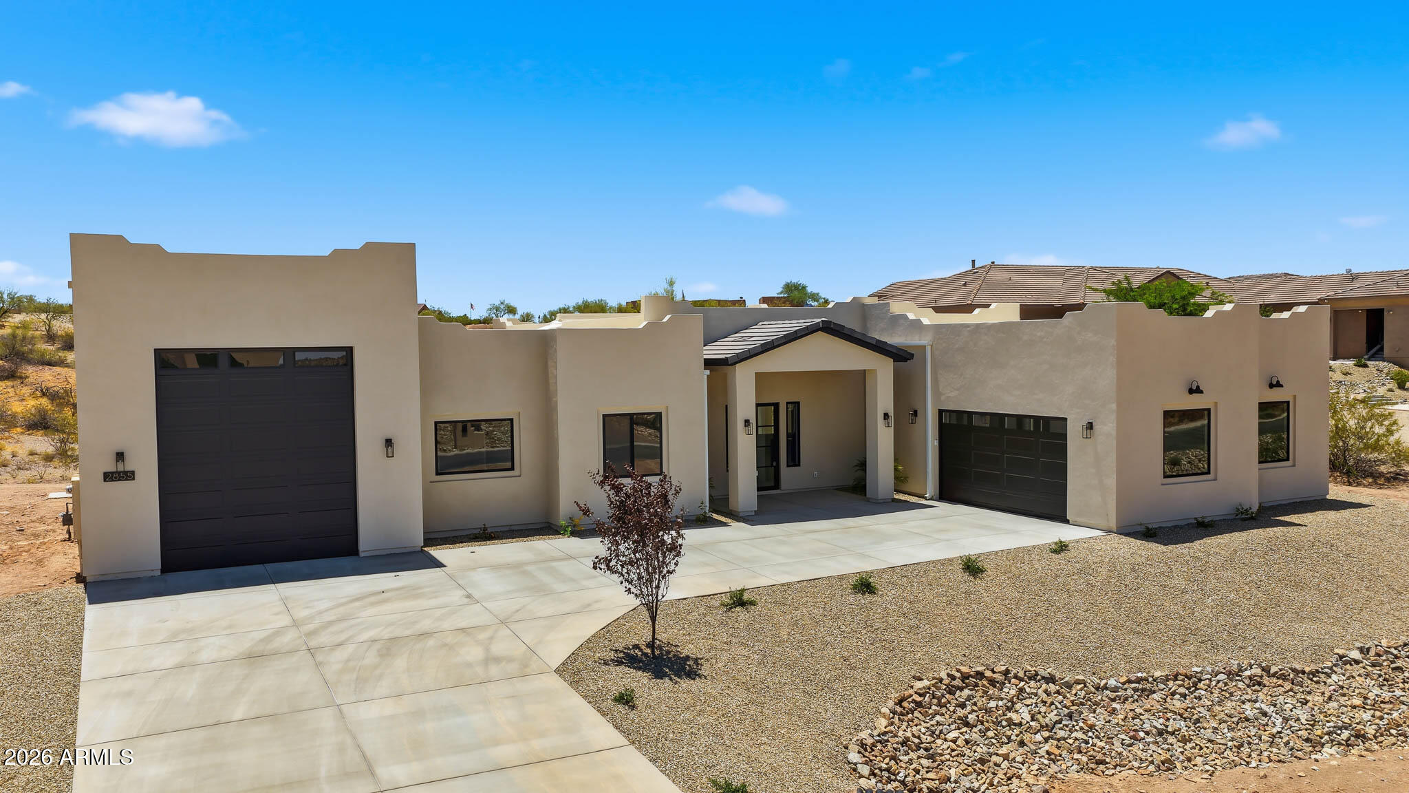 Brand-new Modern Santa Fe home on 0.83 acres in Saddle Ridge West -- finished and ready for its first owners! 2,712 sq ft | 4 bed | 2.5 bath with soaring 12' ceilings, split floor plan, and stunning desert & mountain views. Chef's kitchen with gas range, island, and premium appliances. Living room fireplace, tile flooring, and dual-pane windows throughout. Built with 2x6 framing, spray foam insulation, foam roof, and tankless gas water heater for maximum efficiency. 4-car covered parking includes 2-car garage + RV garage with hookup and EV charger. No HOA. City water & sewer. Adjacent to private-use airport. Priced to sell and move-in ready -- come make it yours!