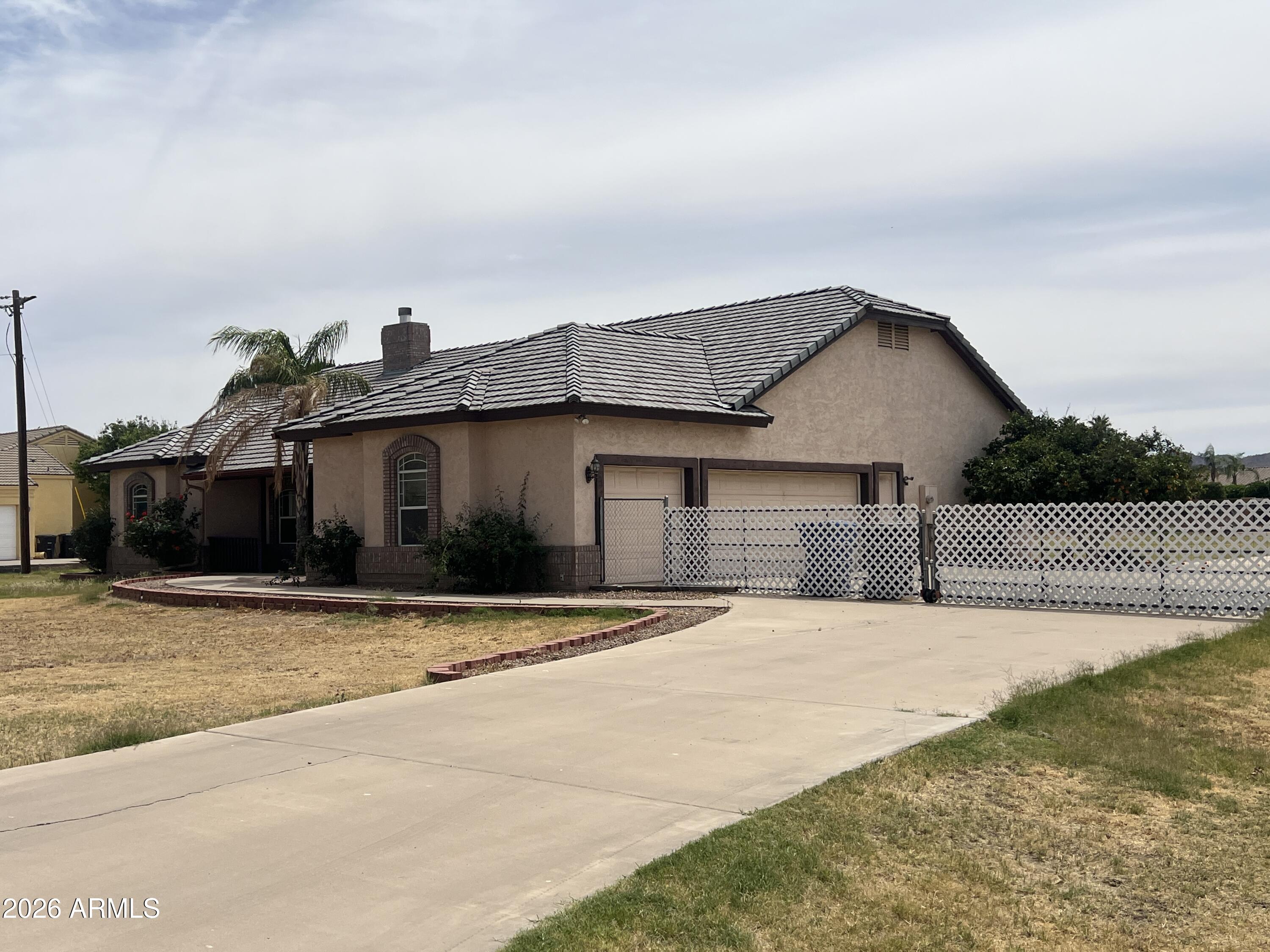 Custom home with a lot of great features but is being sold in ''as-is'' condition and being sold by the DOJ for back taxes.  Huge north/south lot is over an acre with a large slab behind the gate for parking.  Oversized 3 car garage is a plus!
Open Great Room to large kitchen with fireplace separating the great room from a sitting room in front.  Formal dining off kitchen and one primary bedroom split on west end of home and another primary bedroom on east end plus another bedroom and bath on east end.  There is an enclosed patio with 2 ac's that is not included in the square footage from the assessor. There are no utilities on and buyer will need to turn them on in their name for inspections.