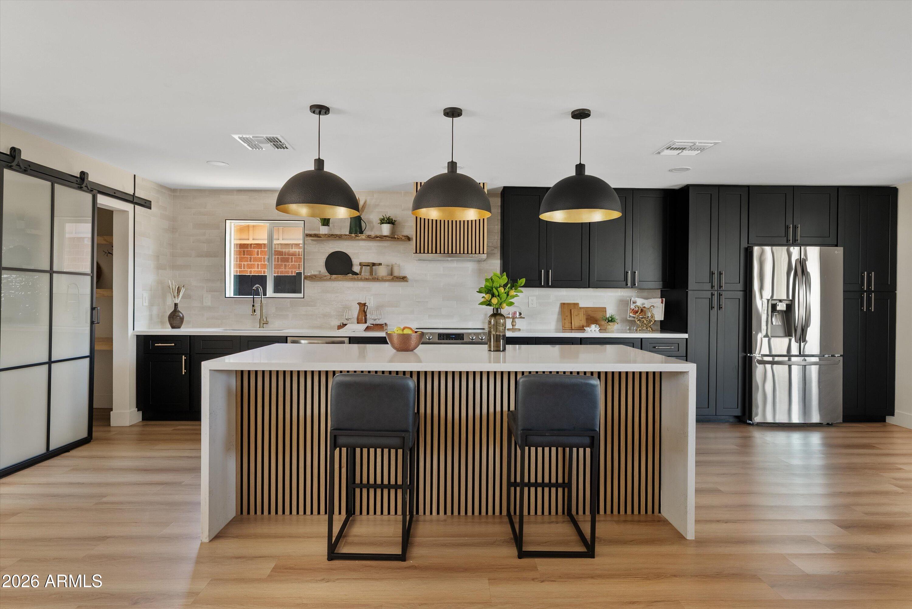 Welcome to this beautifully renovated 1962 home in Scottsdale's sought-after Park Scottsdale neighborhood, where classic red brick charm meets thoughtful modern
design. Reimagined for today's lifestyle, the home offers bright, open living spaces and a seamless connection to the outdoors. At the center of the home is an inviting open-
concept kitchen/family room featuring a stunning waterfall island, stainless steel appliances, and hidden pantry tucked behind a custom barn door--perfect for both everyday
living and effortless entertaining. Dramatic 16-foot sliding glass wall floods the living area with natural light and opens wide to the covered patio, creating an indoor-outdoor living experience, ideal for enjoying Arizona's beautiful weather. Stylish updates throughout. Welcome Home! With stylish updates throughout, modern fixtures, and a two-car garage, this thoughtfully renovated
home blends mid-century character with contemporary comfort. Welcome home!