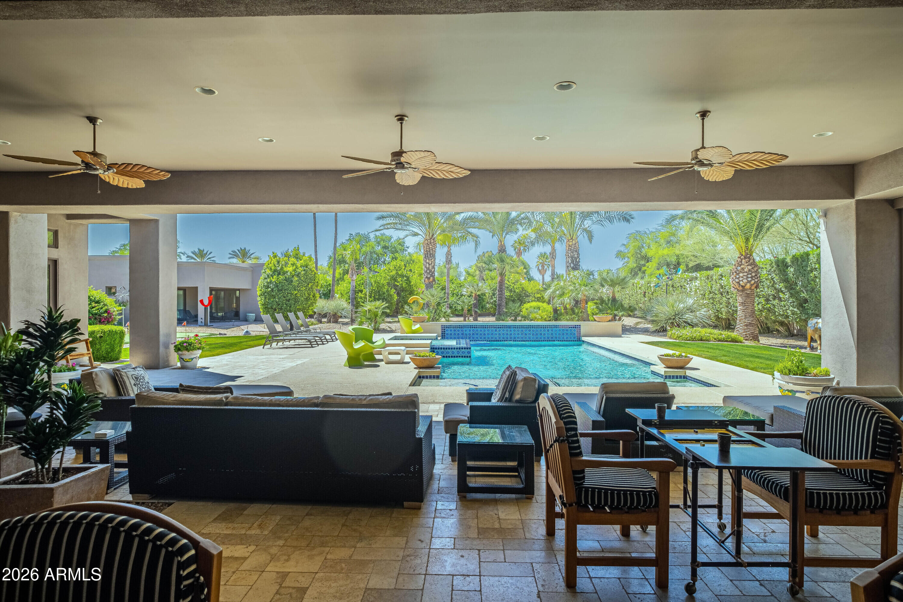 Set on 1.12 acres in one of Paradise Valley's most desirable locations, this soft contemporary estate blends luxury, privacy, and seamless indoor-outdoor living. Custom built in 2004 and extensively remodeled throughout in 2026, the single-level residence spans approximately 5,976 square feet and features 4 bedrooms, 5 bathrooms, and an exceptional split floor plan designed for both entertaining and everyday comfort. The private primary suite occupies its own wing and includes, separate dual oversized closets, separate vanities, individual water closets, a luxurious soaking tub, and a spa-inspired steam shower. On the opposite side of the home, spacious guest suites provide comfort and privacy. Additional highlights include a formal dining room, sophisticated library/office, a state-of-the-art movie room featuring a 113-inch screen, and a dedicated massage and exercise studio designed for wellness and relaxation. Designed as an entertainer's dream, the property showcases approximately 2,000 square feet of covered outdoor patio space, creating the perfect setting for year-round Arizona living. Expansive indoor-outdoor dining areas flow seamlessly to the resort-style outdoor spaces featuring a heated, white opal iridescence fully tiled pool with a raised spa, outdoor barbecue areas, and beautifully curated grounds. The mature landscaping includes a private fruit orchard along with a dedicated putting and pitching green, offering a rare blend of recreation and tranquility. A separate approximately 1,000-square-foot detached casita features its own master bedroom, living area, and two individual bathrooms, creating the perfect private retreat for family, guests, or extended stays while maintaining privacy from the main residence.

Additional features include:
3-car attached garage with direct access
White opal iridescence fully tiled heated pool with raised spa
Three fireplaces, including exterior and primary suite fireplaces
Gourmet kitchen with quartz countertops, gas cooktop, breakfast bar, and large island
12- and 16-foot vaulted ceilings throughout
Wet bar and eat-in kitchen
Circular driveway and cul-de-sac location
No HOA fees