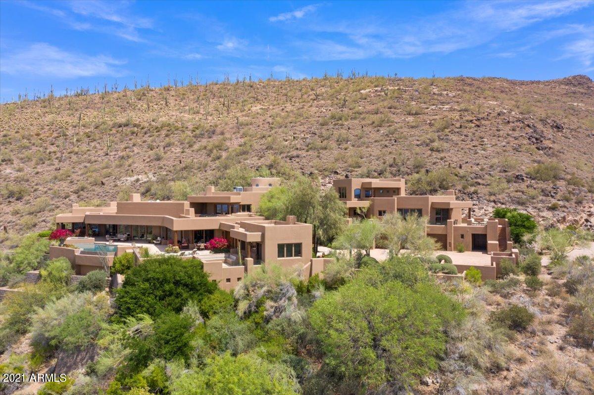 Exquisite Sophisticated Santa Fe....Superb Craftsmanship, & Authentic Finishes unite to create an environment of comfortable sophistication in this timeless Santa Fe soft contemporary home. Perfectly sited on 9 acres at the optimal elevation to afford privacy and the ultimate in valleywide views. Thoughtfully designed by Ron Brissette, and constructed by Linthicum, this outstanding property consists of the primary residence (5737 SF),separate 2 bd/2 ba guest home (1860 SF), + a detached studio/office w/full bath(542 SF). Memorable handcrafted details such as 150 year old reclaimed barn beams & Venetian plaster. Exceptional outdoor entertaining areas include a spectacular entrance patio w/mountainside waterfall, south-facing patios. Adjoining 4.7 Acres avail for purchase separately.