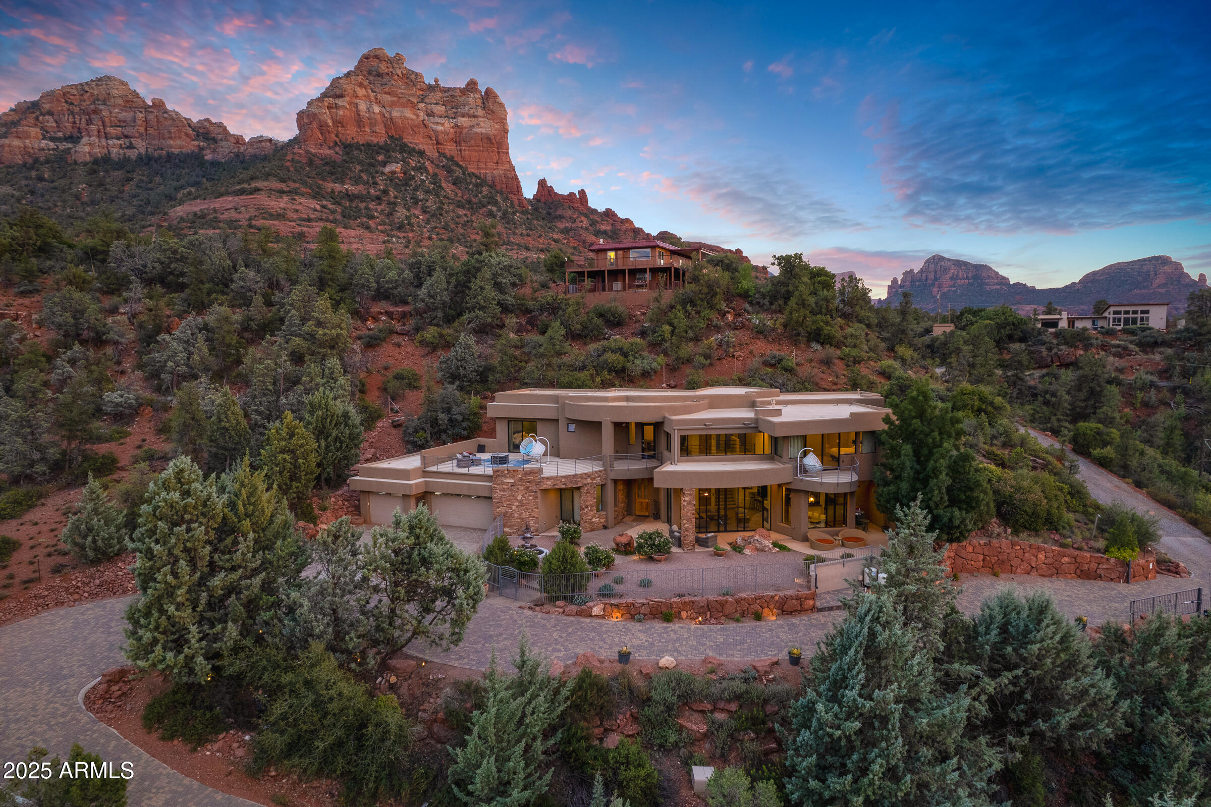 Introducing a rare and exciting chance to own a custom-built home on over three stunning acres in Uptown Sedona—hitting the market for the very first time. With no HOA and zoning of RS-18, this property offers exceptional flexibility, including the rare ability to build additional units—something almost unheard of in Sedona. Additionally, it's Airbnb and VRBO-friendly with no rental restrictions, making it a fantastic investment opportunity.

Built in 2007, the 3 bed, 3 bath main residence is designed to capture breathtaking views with expansive floor-to-ceiling windows. Inside, you'll find a gourmet kitchen, elevator, two master suites with private balconies, a downstairs bedroom, heated floors, and a luxurious steam shower—a perfect blend of comfort and modern style. The historic, self-contained 1-bedroom/1-bath casita is nearly 1,000 sq ft and is tucked away over 50 yards from the main house, offering privacy and versatility. A fascinating piece of history, it was once a workout spot for Elvis Presley during a Western film shoot in the 1960s. The casita can be rented separately, adding even more potential to this extraordinary property.

With incredible views, a prime location, and unmatched potential, this Sedona estate is a unique find that promises both lifestyle and investment rewards. Don't miss your chance to make it yours