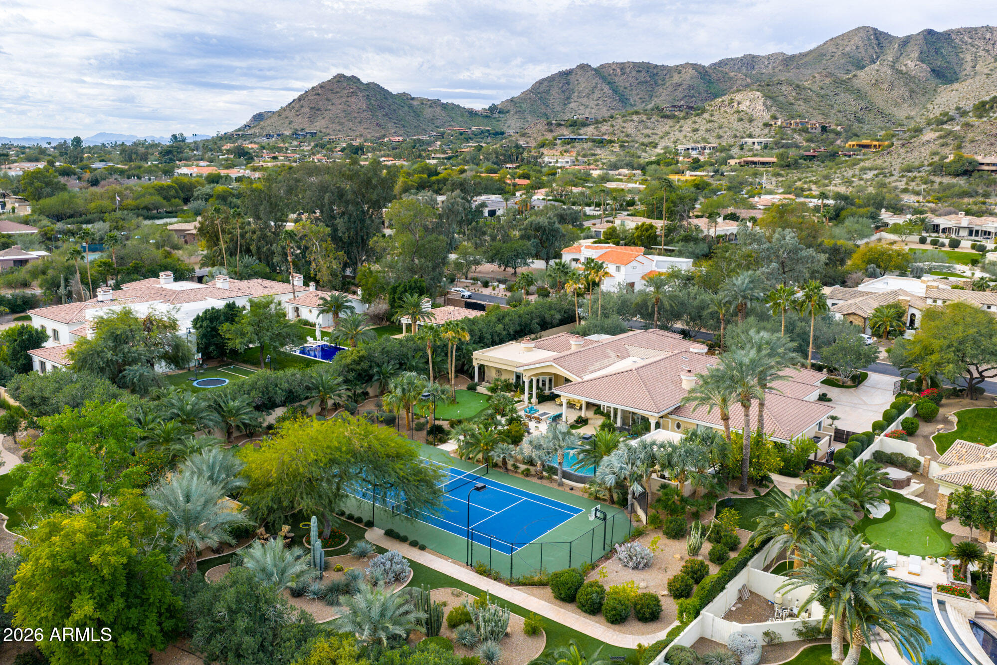 Nestled in the heart of Paradise Valley, this stunning estate—renovated by Cullum Homes—offers modern luxury with timeless elegance. The open design highlights a great room with fireplace, new wall of sliders, and a formal dining area. The chef's kitchen is fully redesigned with high-end appliances, dual dishwashers, multiple ovens, custom cabinetry, stone counters, a walk-in pantry, and a sunny breakfast nook. The primary suite is a private retreat featuring a cozy fireplace, sitting room, gym, backyard access, dual closets, dual toilets and sinks, a steam shower, oversized walk-in shower, freestanding tub, and its own washer and dryer. Resort-style amenities continue outdoors with mountain views, desert landscaping, mature fruit trees, heated pool and spa, tennis court, putting green, raised garden beds, and a chicken coop. Entertain with ease under the new outdoor Ramada kitchen equipped with BBQ, pizza oven, smoker, and mini fridge. The thoughtful split floor plan includes a soundproof theater, playroom, executive office, and garage with custom storage, epoxy floors, and dual HVAC systems. This one-of-a-kind property perfectly blends luxury, functionality, and Arizona's natural beauty an exceptional opportunity in Paradise Valley.