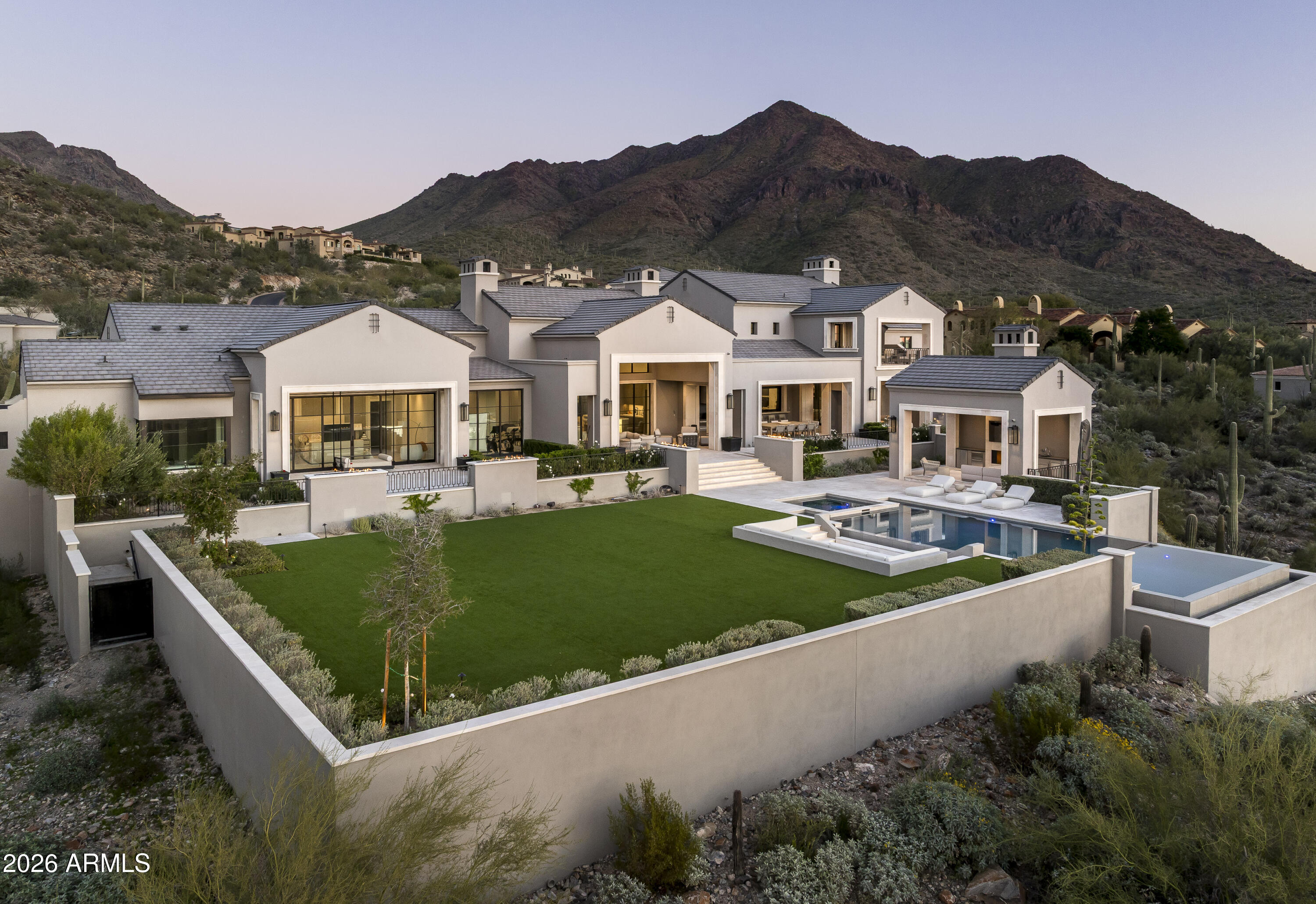 Privately gated within Silverleaf's prestigious Upper Canyon, this impeccably crafted custom estate—designed in collaboration with PHX Architecture, Sommer Custom Homes, and Ownby Design—sits on nearly 4.5 acres and offers a rare balance of grand scale, privacy, and effortless livability. The residence is defined by soaring ceilings, light wood flooring, and a striking book-matched marble fireplace, complemented by sweeping city-light views, vibrant sunsets, mountain views, and an expansive turf yard—hard to find on hillside estates in this exclusive enclave.
Designed for seamless indoor-outdoor living, the open-concept kitchen, dining, and living spaces flow effortlessly to the outdoors. The chef's kitchen is anchored by a full back kitchen and multiple ovens, perfectly suited for both elevated entertaining and everyday living. Oversized glass sliders in the great room and family room open to covered patios outfitted with sunshades, misters, heaters, and a built-in BBQ creating an ideal setting for year-round gatherings and alfresco dining.
The entry-level primary retreat is a true sanctuary, featuring a dedicated exercise room and private office. As you enter the bedroom, your eye is immediately drawn to the private patio and endless views beyond. The retreat is completed by two custom walk-in closets and a spa-inspired bath with sauna, steam shower, outdoor shower, cold plunge, and a secluded patio designed for ultimate relaxation.
Five spacious guest en-suite bedrooms, each with walk-in closets, provide exceptional comfort for family and guests. Additional living spaces include a private theater, a dedicated kids' recreation room, and a private family room, offering versatility and space for every lifestyle.
The resort-style backyard is highlighted by a negative edge pool and spa, along with a covered cabana featuring a pool house bath. A six-car garage accommodates an extensive vehicle collection. Ideally located just moments from Scottsdale's premier dining, shopping, and resort destinations, this exceptional estate delivers refined luxury in one of Arizona's most coveted communities.
Silverleaf, located in North Scottsdale, Arizona, is a prestigious guard gated community known for its luxurious estates, exclusive golf courses, private Club and stunning desert landscapes. The Tom Weiskopf-designed Silverleaf Golf Course is a highlight for golf enthusiasts. With a blend of Spanish and Mediterranean-inspired architecture, the community offers a high standard of living, including upscale amenities like spas, fine dining, and exclusive shopping. Residents enjoy a harmonious balance between modern luxury and the natural beauty of the desert environment, making Silverleaf a sought-after destination for those seeking an exceptional lifestyle in North Scottsdale.