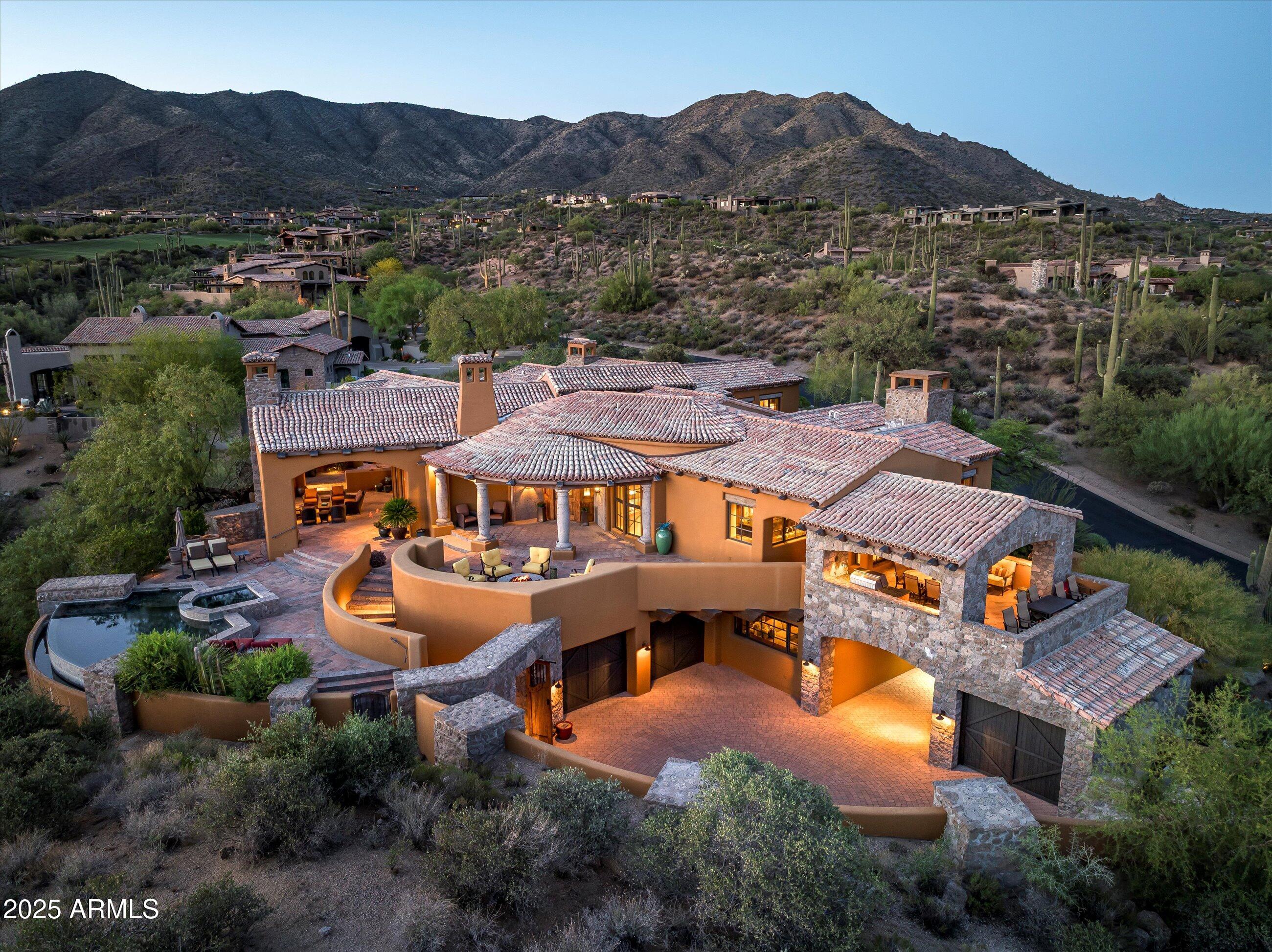 DESERT MOUNTAIN GOLF MEMBERSHIP AVAILABLE. Embrace a casual yet elegant resort lifestyle in the stunning Mediterranean hillside home in Village of Saguaro Forest within the prestigious guard-gated Desert Mountain Club in North Scottsdale, AZ. This home showcases the Lee Hutchison design with a floor plan that  perfectly accommodates entertaining and family living in & out. The great room welcomes you to a gorgeous  stone wall & Cantera fireplace, vaulted beamed ceilings and inviting bar. A raised grand dining room overlooks living room and valley views beyond. Chef's Kitchen and cozy Hearth room offer panoramic mountain & city views.  Primary suite has its own private patio with fireplace. Game/Media Room can be 5th Bedroom w/en-suite bath. Pristine craftsmanship throughout.