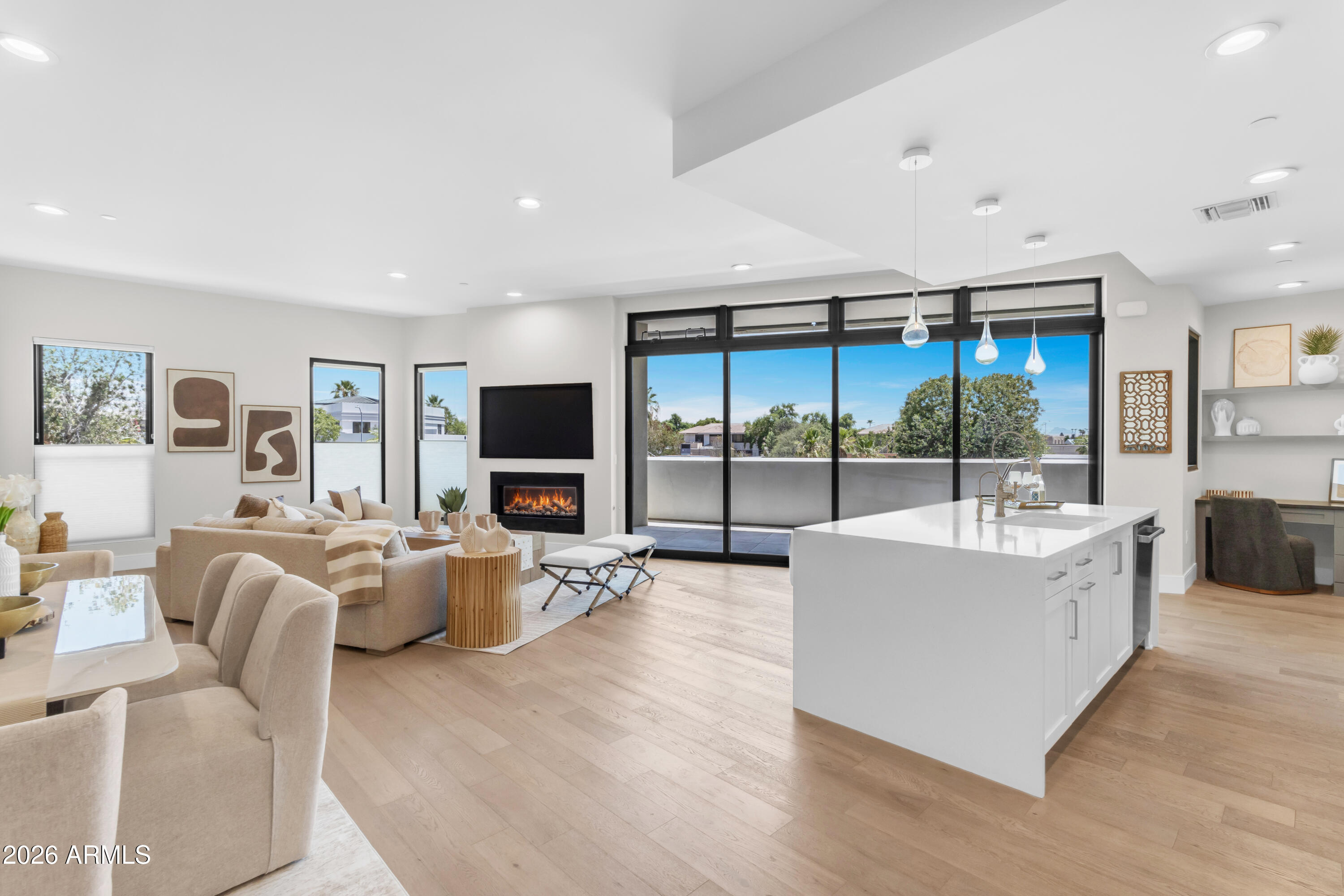 Distinctive contemporary design meets premier urban convenience at Main Street Place in Old Town Scottsdale. This exceptional single-level luxury residence offers an expansive, light-filled layout boasting premium hardwood floors, soaring flat ceilings, and superior sound engineering for ultimate privacy. The gourmet kitchen features top-of-the-line appliances, a generous eat-in island, and a walk-in pantry, seamlessly flowing into the spacious living and dining areas. Slide open the glass doors to a large, private covered terrace showcasing beautiful views of the McDowell Mountains and city lights. The master suite features an opulent bath with a separate tub and walk-in shower. Complete with a versatile den/office space and secure two-car parking. Walk to the arts district, elite fashion square shopping, and iconic dining. Exclusive building amenities include a 24/7 fitness center, heated resort spool, fire pit, and resident clubroom.