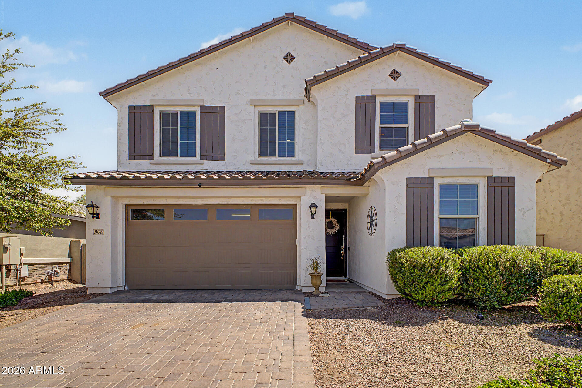 Beautiful two-story home in Verrado is sure to impress! Offering 3 beds, 2 baths + powder room, manicured landscape, & a 2-car garage w/paver driveway. The inviting interior features tons of natural light, tall ceilings, a neutral palette, and carpet & wood-look tile flooring t/out. Discover a seamlessly flowing open layout paired with multi-sliding doors to the back! The spotless kitchen boasts SS appliances, granite counters, a pantry, recessed lighting, white cabinets, and an island w/breakfast bar. Cozy den downstairs can be an office or extra bedroom. All bedrooms are upstairs, along with a flexible loft! Main bedroom has an ensuite with a barn door, dual sinks, & a walk-in closet. Enjoy the large backyard with a covered patio, well-laid pavers, artificial turf, & a Pergola! Just WOW!