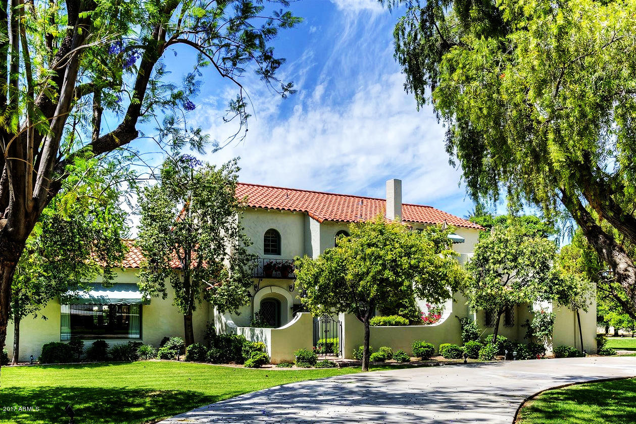 Historic Spanish Colonial Revival Estate located on one of the most exclusive tree-lined streets in the heart of Arcadia. Enter the private gates of this one-of-a-kind nearly 2 acre lush green property nestled at the base of Camelback Mountain. Once considered for the state Governor’s mansion, and later serving as Miss Kitty of Gunsmoke’s residence for 17 years, this iconic 1920’s home exudes character, charm, and elegance! The home is beautifully situated back from the street offering privacy and grandeur. Outside highlights include arched windows, iron balconies, Moreno tiled entryway that leads to a front door with delicately patterned stained glass. Remodeled numerous times, this light airy 6400 + sq ft open floor plan is a perfect haven for families and amazing for entertaining with multiple french doors leading to the back patio. This 5 Bedroom and 4 Bath home also has a large sunny pool room for convenient access to the pool and spa. The Showpiece Gourmet Kitchen has light-colored slab granite, commercial 6 burner gas range, double ovens, double dishwashers, three sinks, SubZero Refrigerator, and a large walk-in pantry. The Master Suite is located on the first floor with Luxurious Spa-like Master Bath and beautiful oversized shower.  The first floor includes a casually elegant living room with 11 ft coved ceiling, majestic mountain views, and a fireplace modeled after the nearby Phoenician's.  The kitchen and oversized family room boast brick walls from the original 1920's home.  Also on the main floor is a private two-stationed custom office, formal dining room with a domed ceiling, grand crystal chandelier, clear leaded glass transoms, domed ceiling foyer, and cozy library off the living room. In the former basement is a new walk-in 1500 bottle wine room, wine-tasting room, and a large work out room with herringbone patterned brick floors.  Resort style grounds include numerous patios, oversized 42' long pool, large 12 person Jacuzzi/spa, outdoor kitchen, and Hopi/Arcadia schools. Too many extras to list!  Featured on the cover of Phoenix Home and Garden and selected for the prestigious Palette of Homes Tour. This piece of Arcadia magic can be your dream home!