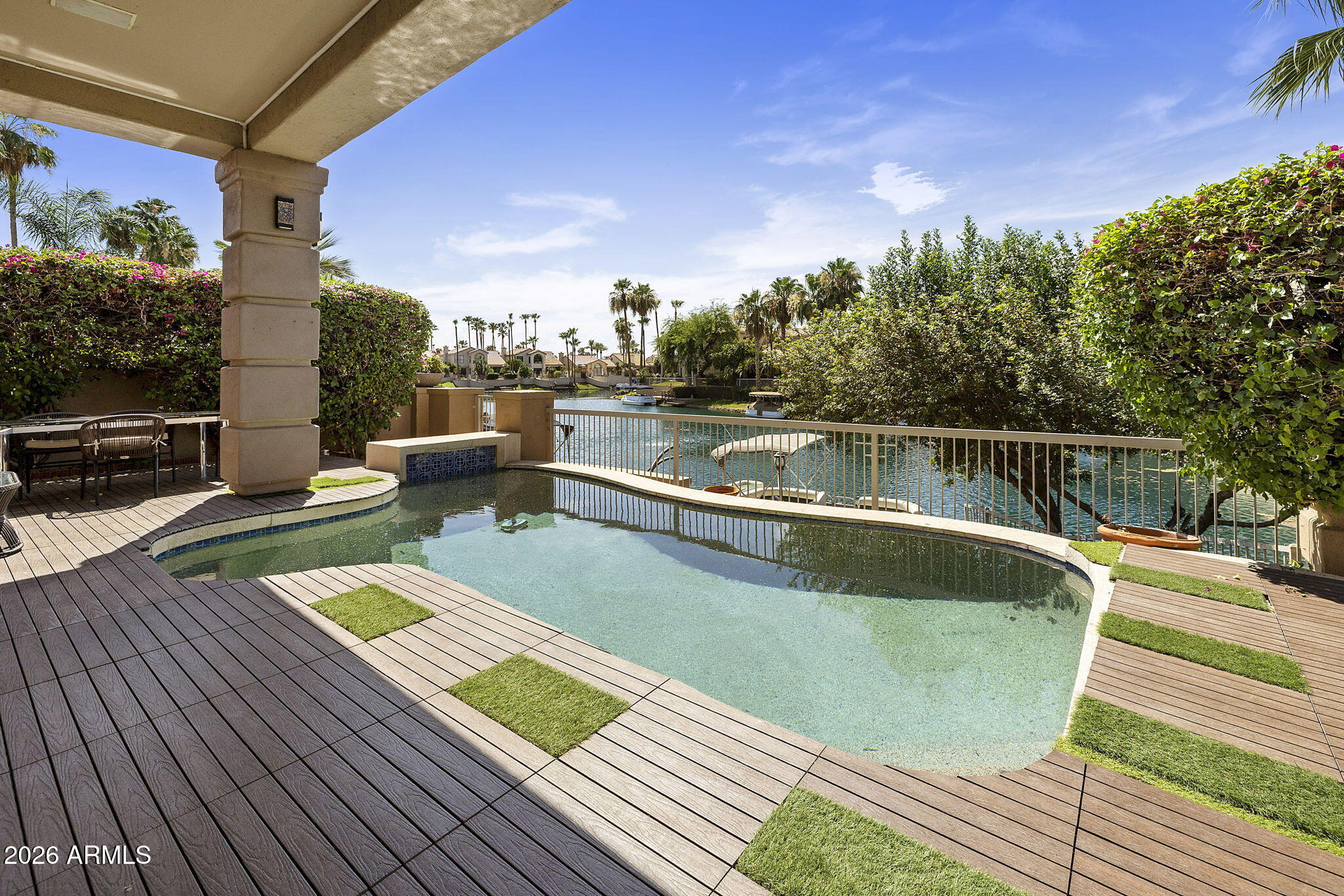 Welcome to WATERFRONT luxury living in The Landings at Scottsdale Ranch, one of Scottsdale's most coveted gated lake communities. This completely REMODELED 4 bedroom, 3.5 bath home sits directly on the shores of Lake Serena, offering an unmatched blend of designer finishes and resort style living. A grand front courtyard welcomes you home and sets the stage for outdoor dining and entertaining before you even step inside. The main level is anchored by a stunning primary suite, offering privacy and convenience rarely found in lakefront homes. Upstairs, three spacious guest bedrooms provide flexible space for family and visitors, including one with its own ensuite bathroom. Step out onto the second-floor balcony and take in sweeping vistas of Lake Serena and the iconic McDowell Mountains. A custom iron stair railing serves as a dramatic design centerpiece connecting the two levels. Every inch of this home has been thoughtfully curated in today's modern style, from the designer light fixtures and European style light switches throughout to the luxury vinyl plank flooring that flows seamlessly across every room. This smart home is fully wired for today's technology, offering seamless connectivity and modern convenience at every turn. The chef's kitchen features a professional ZLine gas cooktop and opens beautifully to the living areas for effortless entertaining. The backyard oasis offers a full outdoor kitchen, sparkling private pool, and your own boat dock on Lake Serena. Scottsdale Ranch amenities include 5 miles of shoreline, boating, fishing, tennis, parks, and the Mercado. Easy access to the 101 and world-class dining and shopping complete this rare lakefront opportunity.