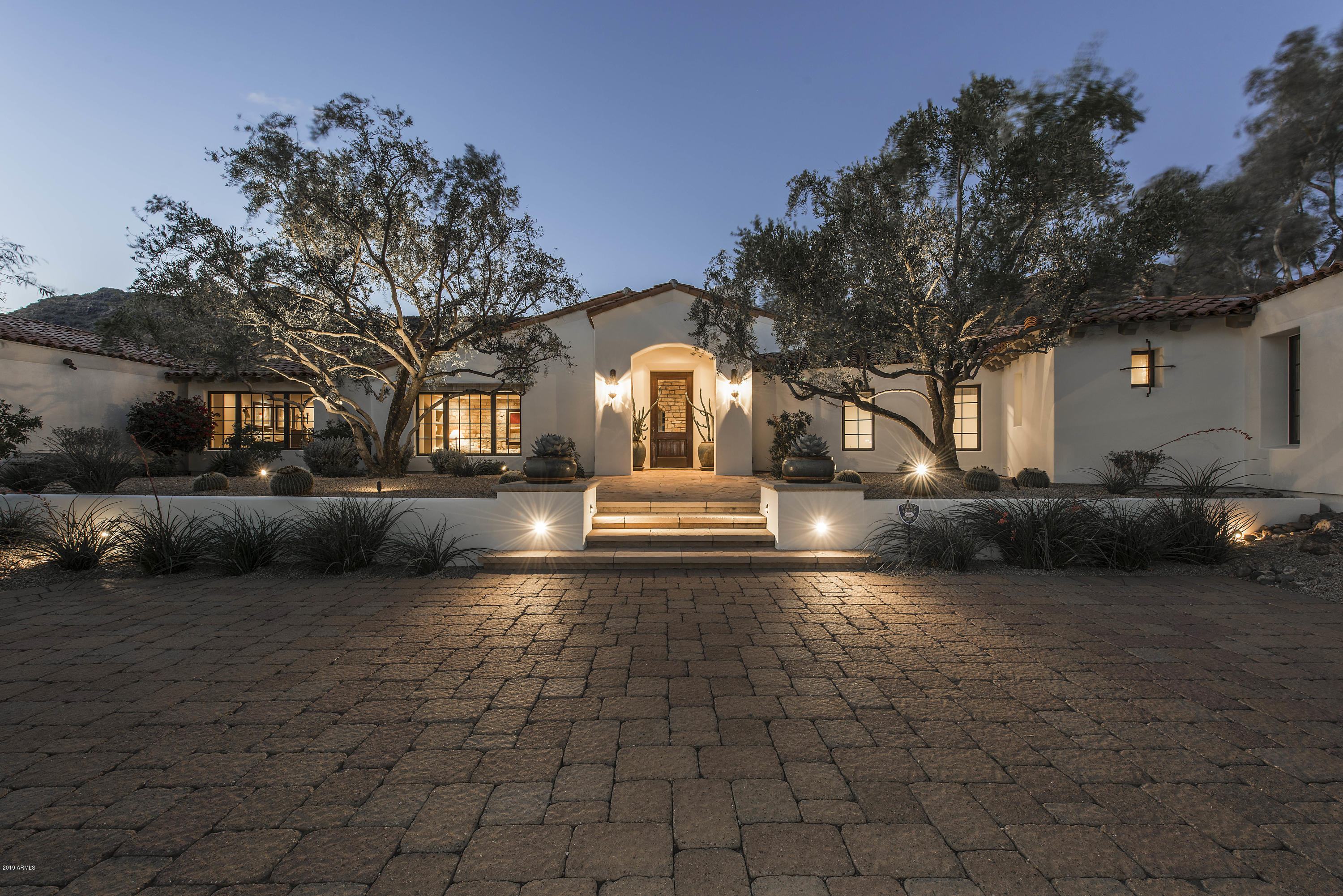 Elegant 1.25 acre Santa Barbara estate between Camelback and Mummy Mountains is positioned perfectly for privacy and views. From the moment you enter the foyer of this home you will be enchanted by the 170 year old French Terra Cotta floors and Texas Limestone accented walls. Home features a wonderful light kitchen with an abundance of cabinetry, open great room and home theatre with 107'' screen that seats 10. Four en-suite bedrooms, plus an exercise room, bar, and 300 bottle wine room in the main house. You will enjoy retiring to the master retreat with a roomy sitting area, great private views, spacious his and hers closets, a luxurious bath which includes a large soaking tub, expansive shower and large vanity area that opens onto a private courtyard with an antique limestone fountain. Recent upgrades include new gray oak floors in the work out room, hall and master suite. New honed granite counters and tile backsplash in the kitchen, butlers pantry, laundry, office and guest house bath. New carpet in all secondary bedrooms. Separate guesthouse with complete kitchen, living and separate bed and bath are perfect for long term guests or caretaker quarters. Lush natural landscaping, with specimen Ironwood and Mesquite trees, Meyer Lemon trees, sparkling pebble sheen pool, turf lawn areas and fireplace complete the outdoors spaces of this wonderful estate. Don't miss the separate office or art studio with its own private entrance. For the car lovers - this home boasts 6 expansive garage spaces. Call to schedule a tour today, you will be impressed with the charm and warmth of this home! Total SF includes main house at 6,284 SF, Guest House 1,033 SF